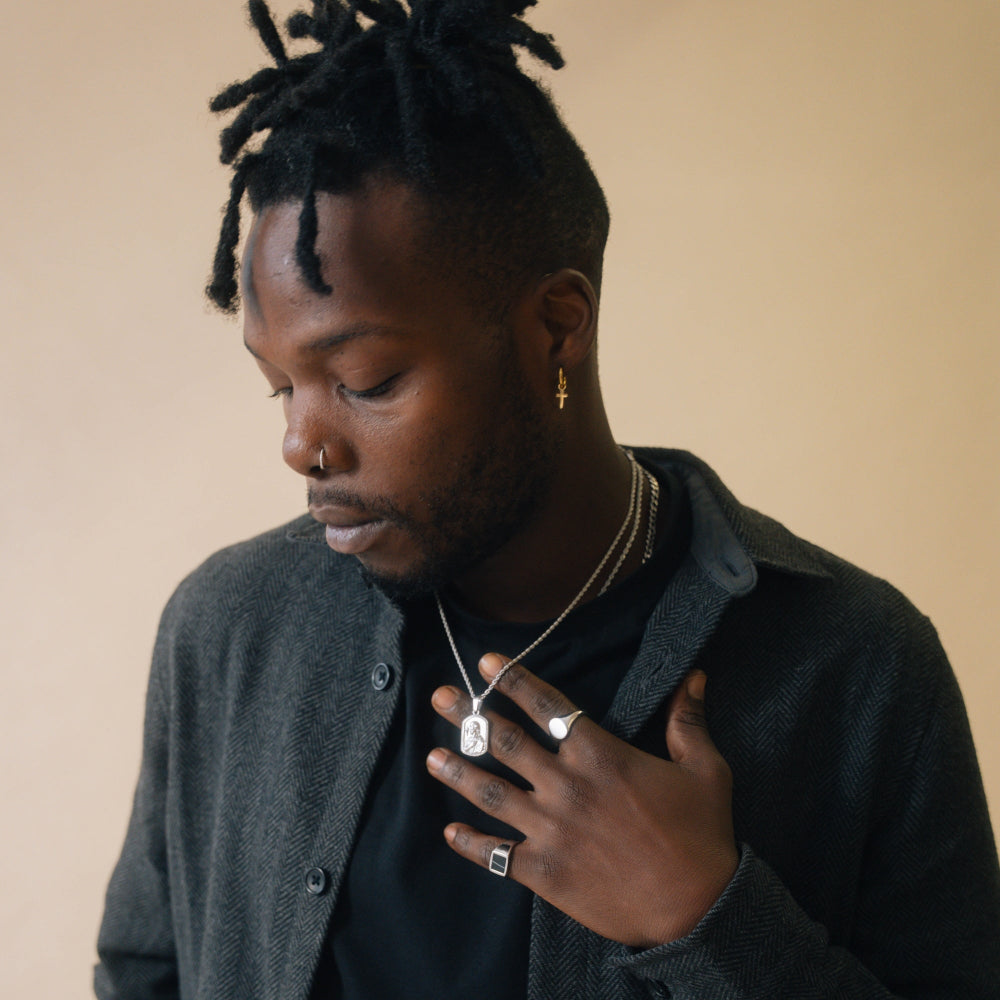 Man adjusting his jacket with a neutral background