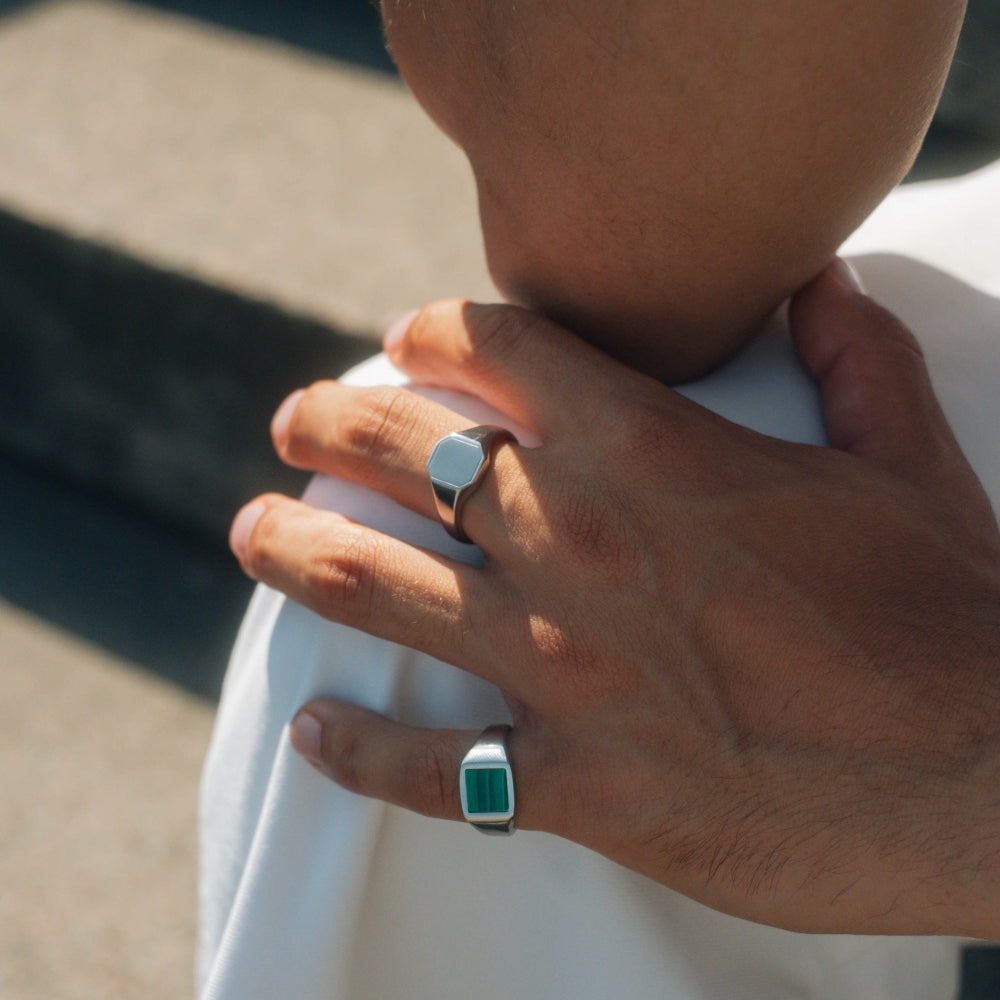 Close-up of a hand wearing two rings with a blurred background