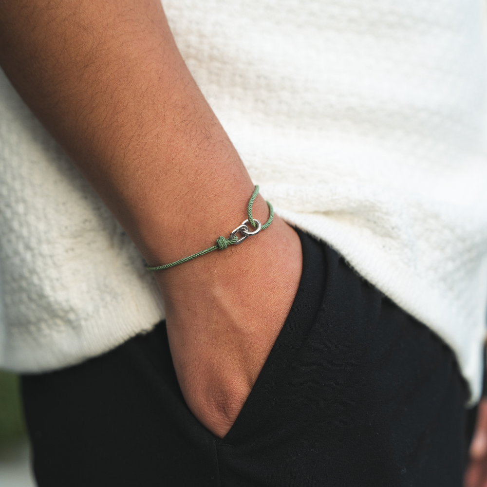 Person wearing a green bracelet on a blurred background