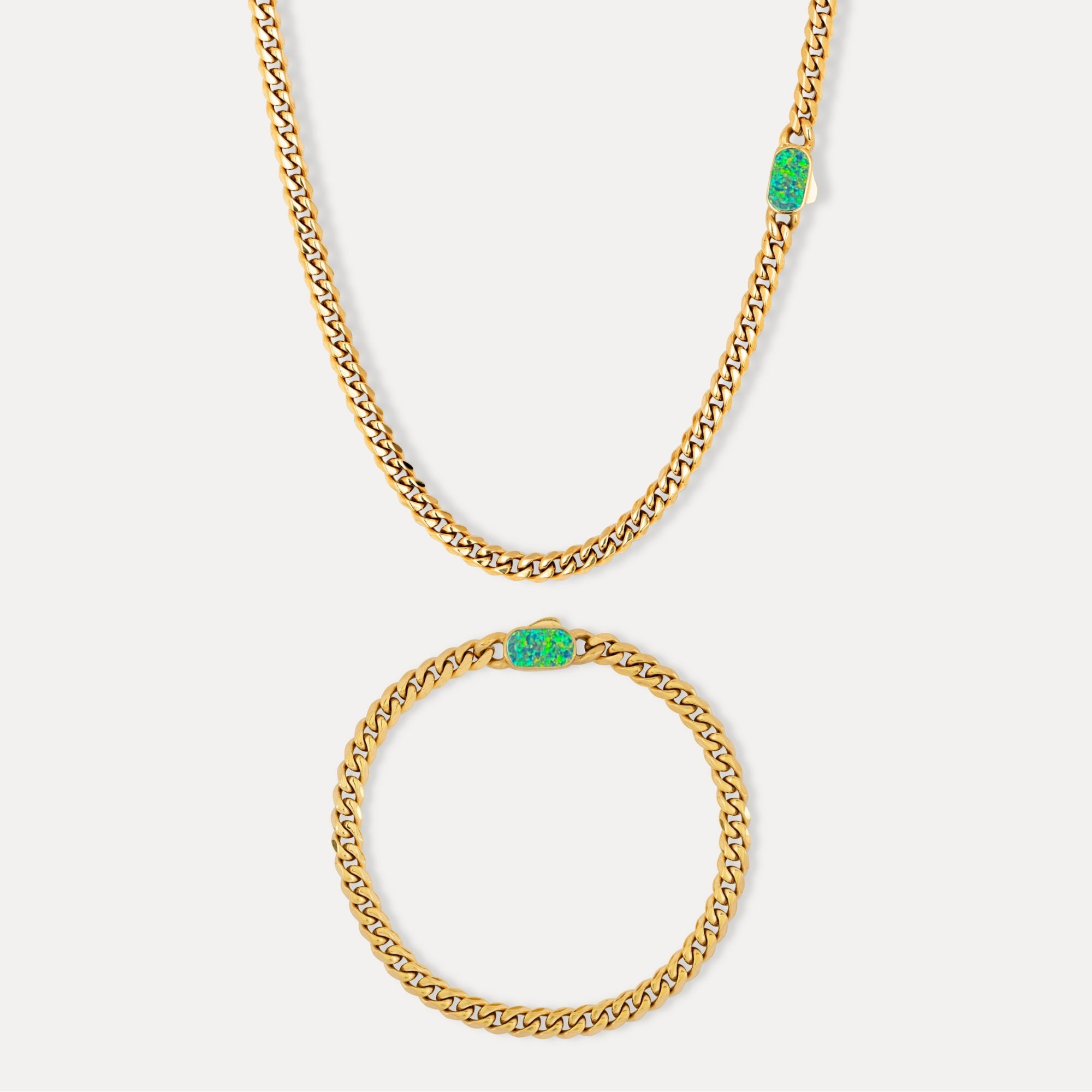 Gold chain necklace with green pendants on a white background