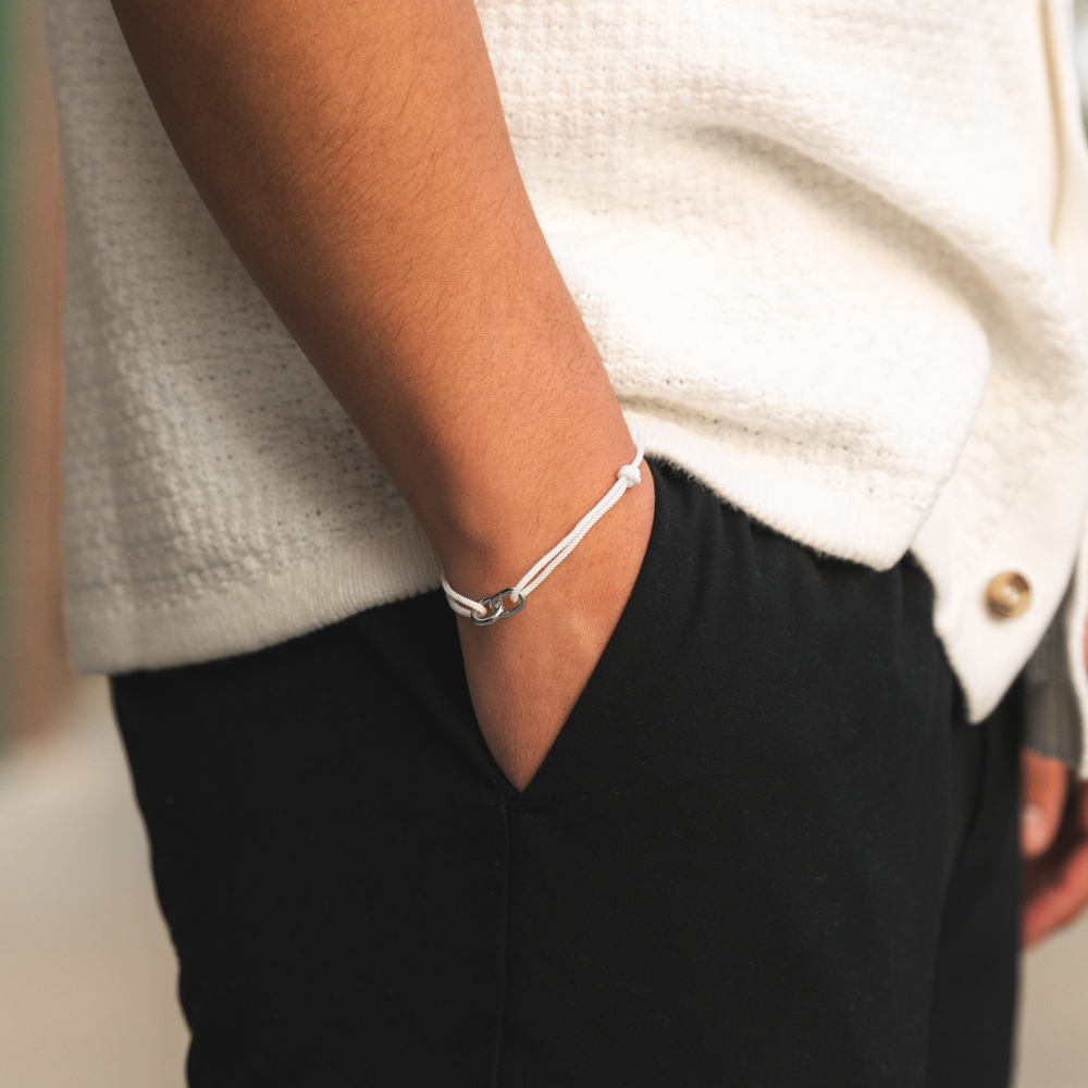 Person wearing a silver bracelet on a blurred background