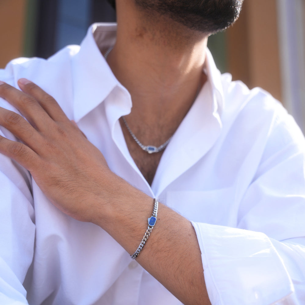 Person wearing a white shirt with a bracelet on a blurred background