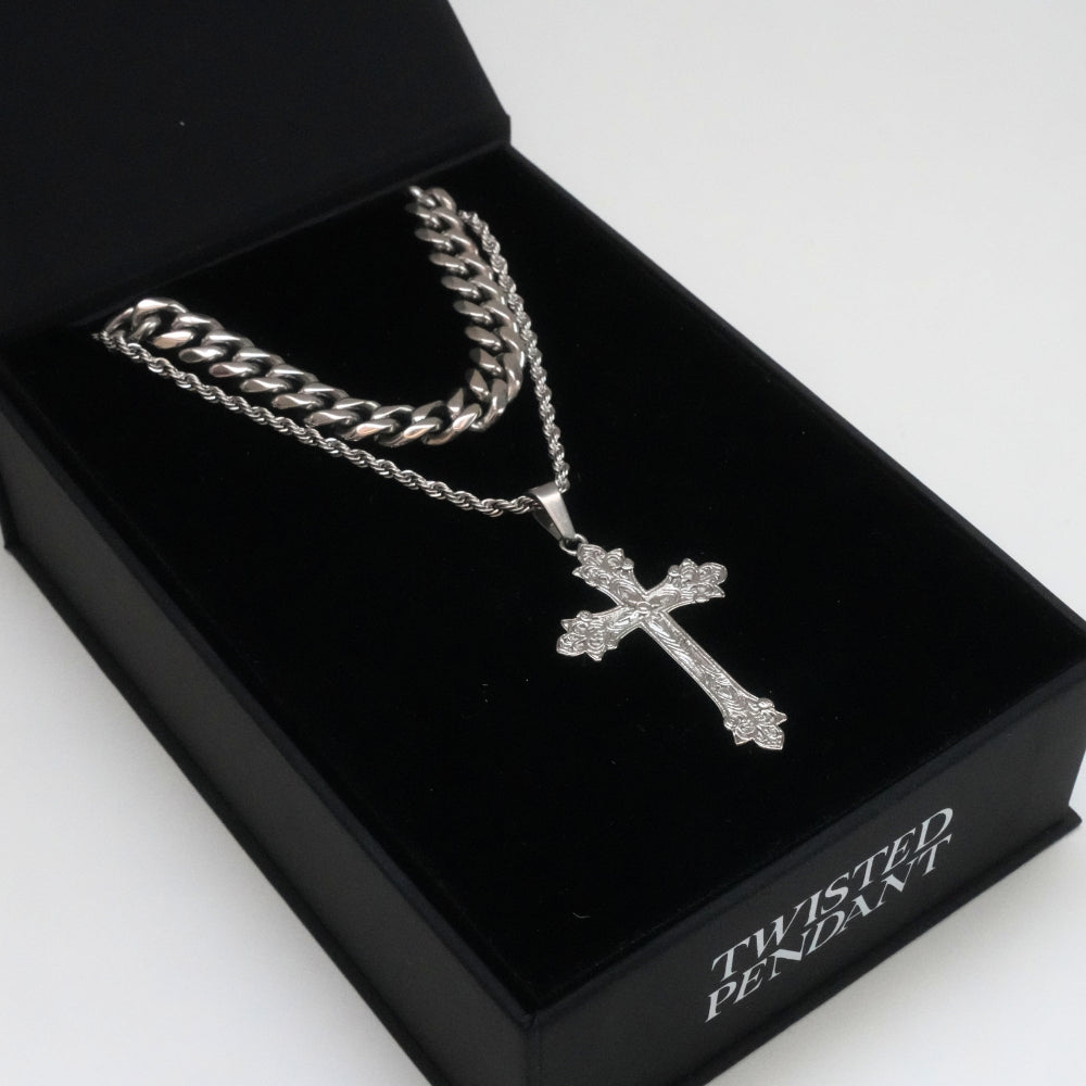 Silver chain necklace with a cross pendant in a black box labeled 'Twisted Pendant'.