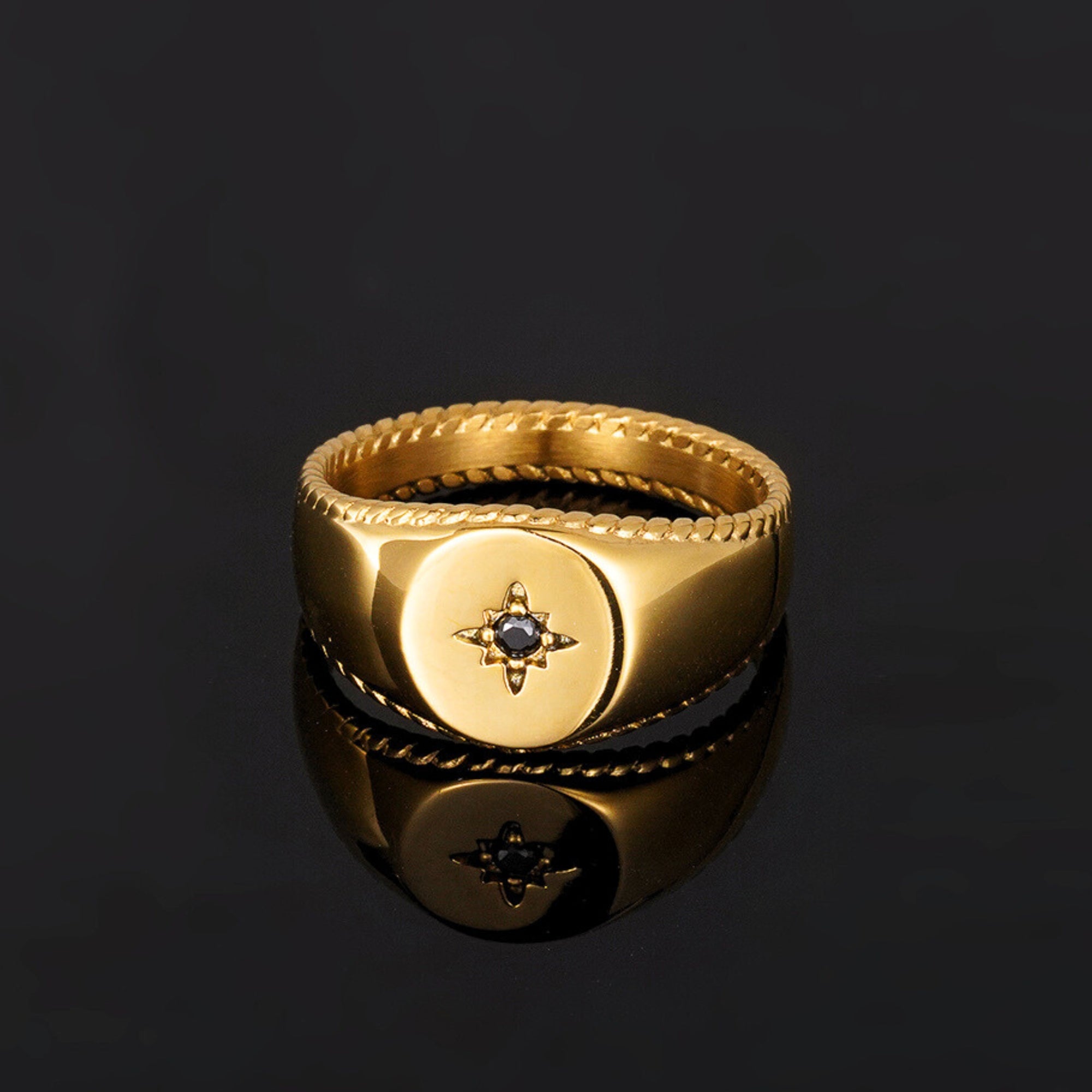 Gold ring with a central gemstone on a black background