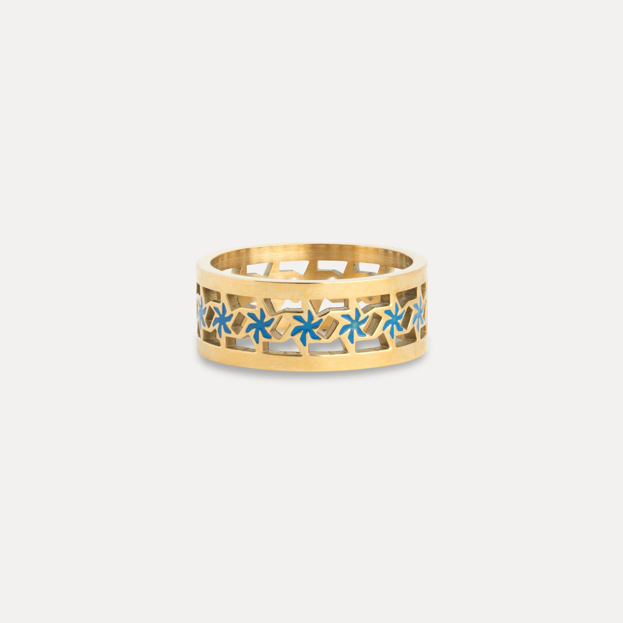 Gold ring with blue floral patterns on a light gray background