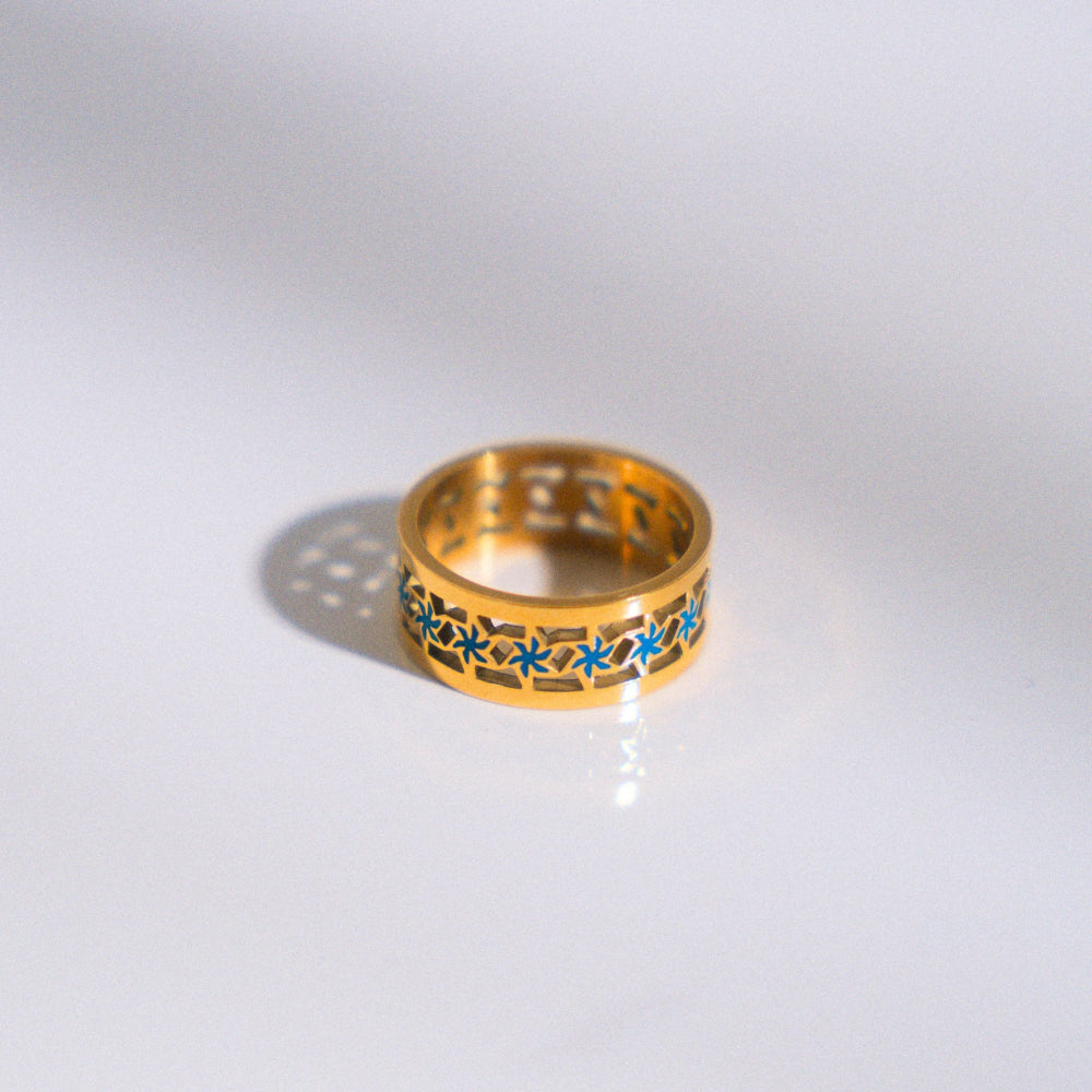 Gold ring with blue accents on a white background