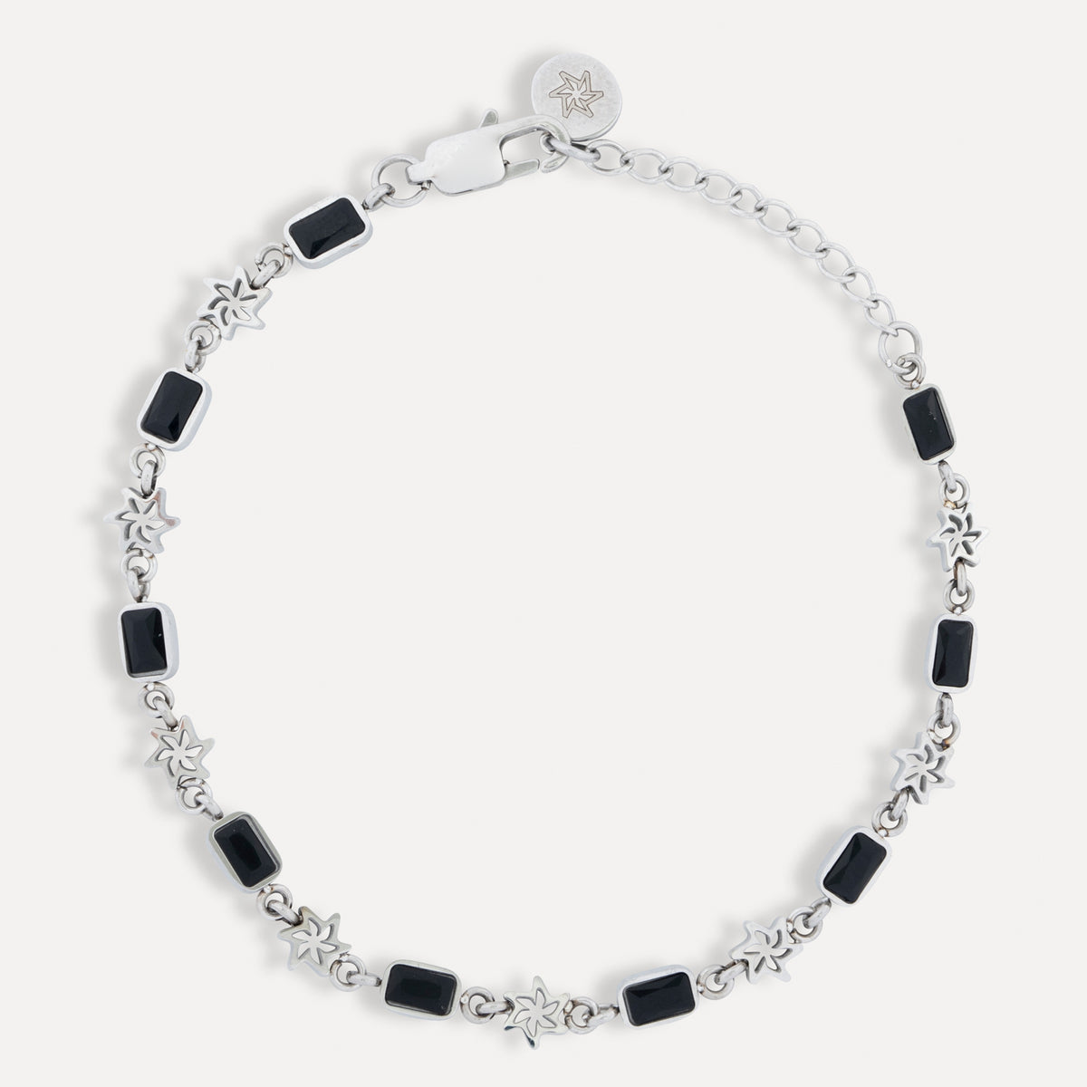 Silver bracelet with black square beads on a white background