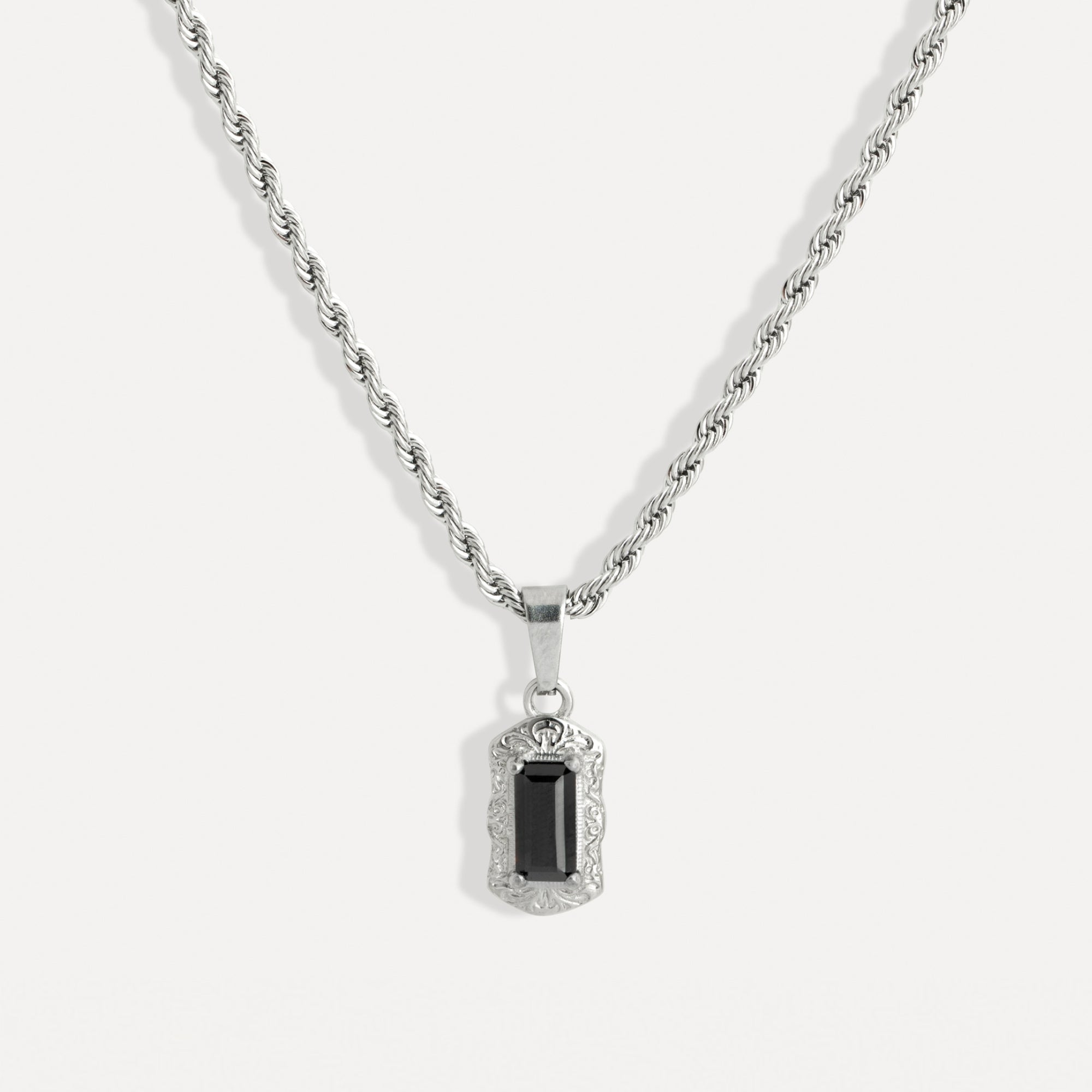 Silver necklace with a black gemstone pendant on a white background
