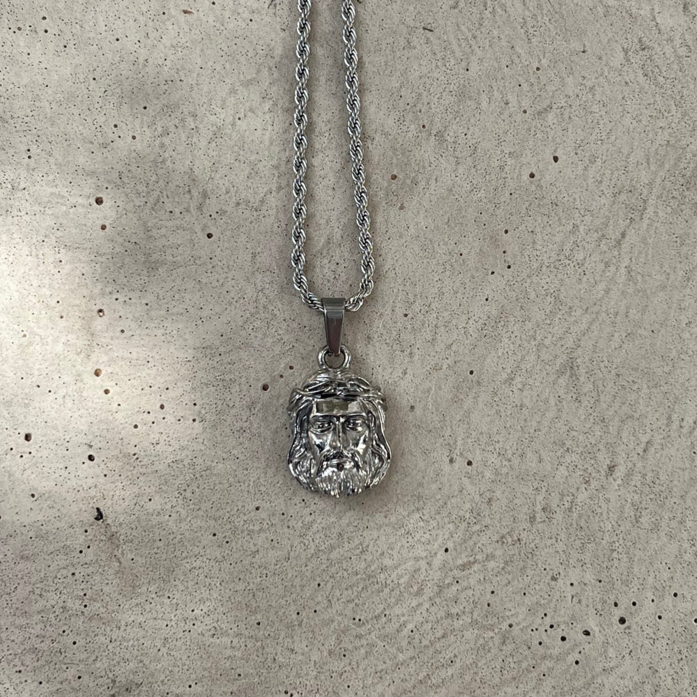 Silver pendant necklace on a textured gray surface