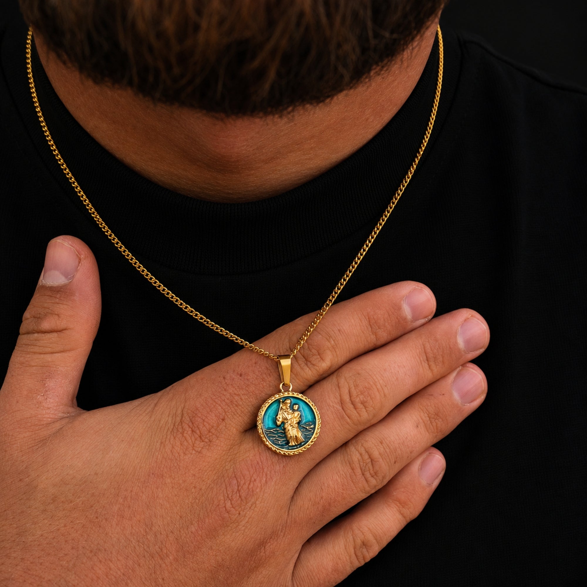 Gold necklace with a pendant worn by a person against a black background