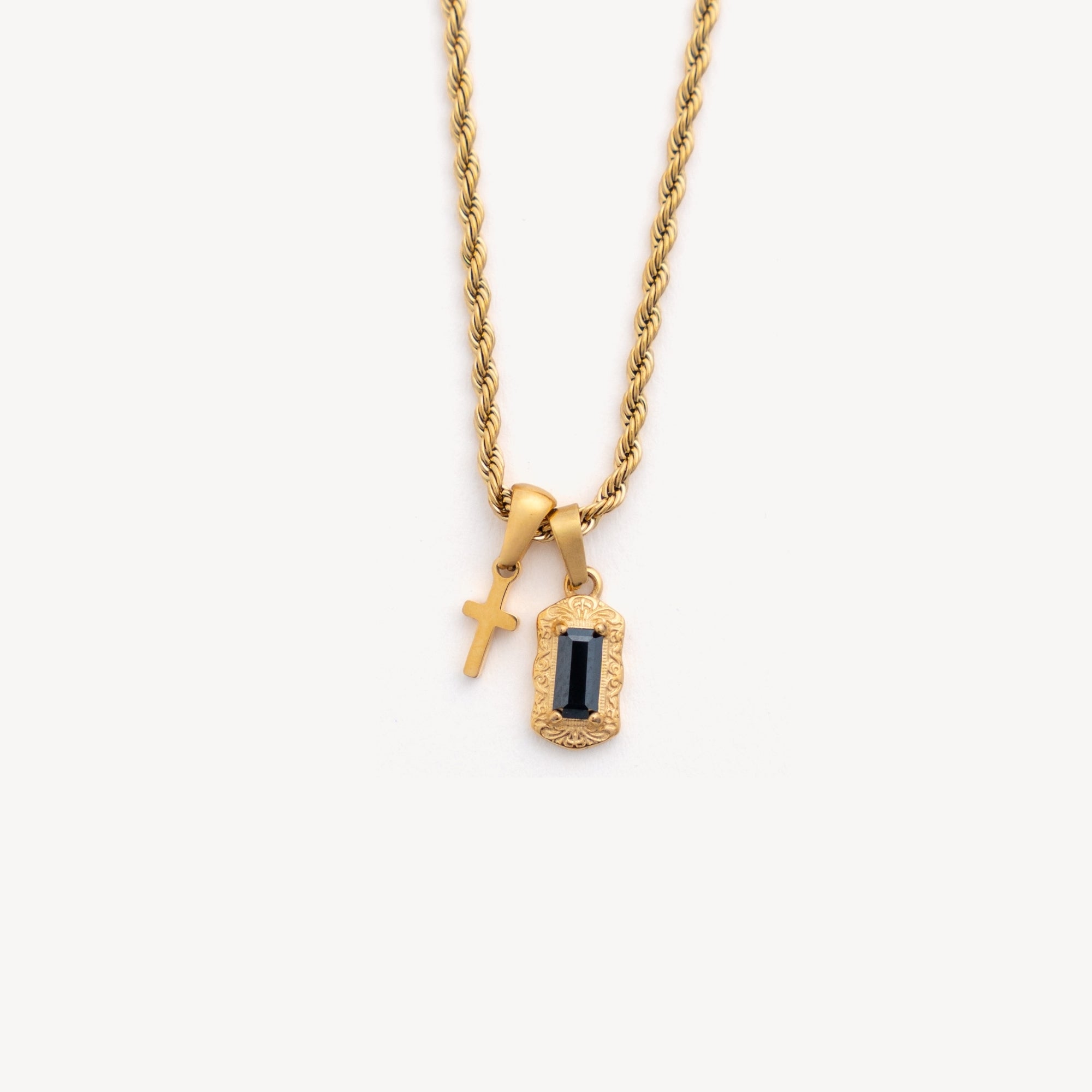 Gold necklace with two pendants on a white background