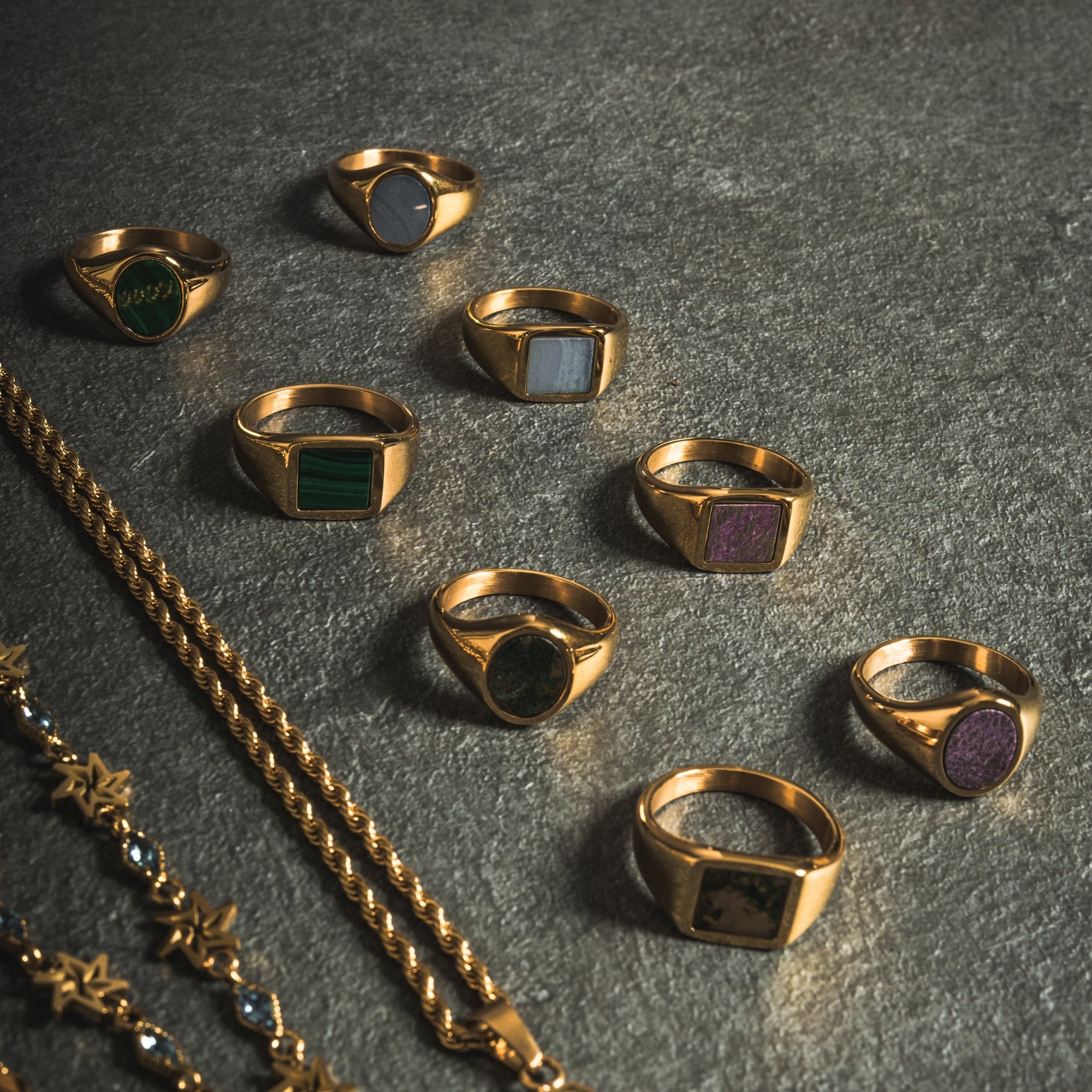 Gold rings with colored stones on a dark surface