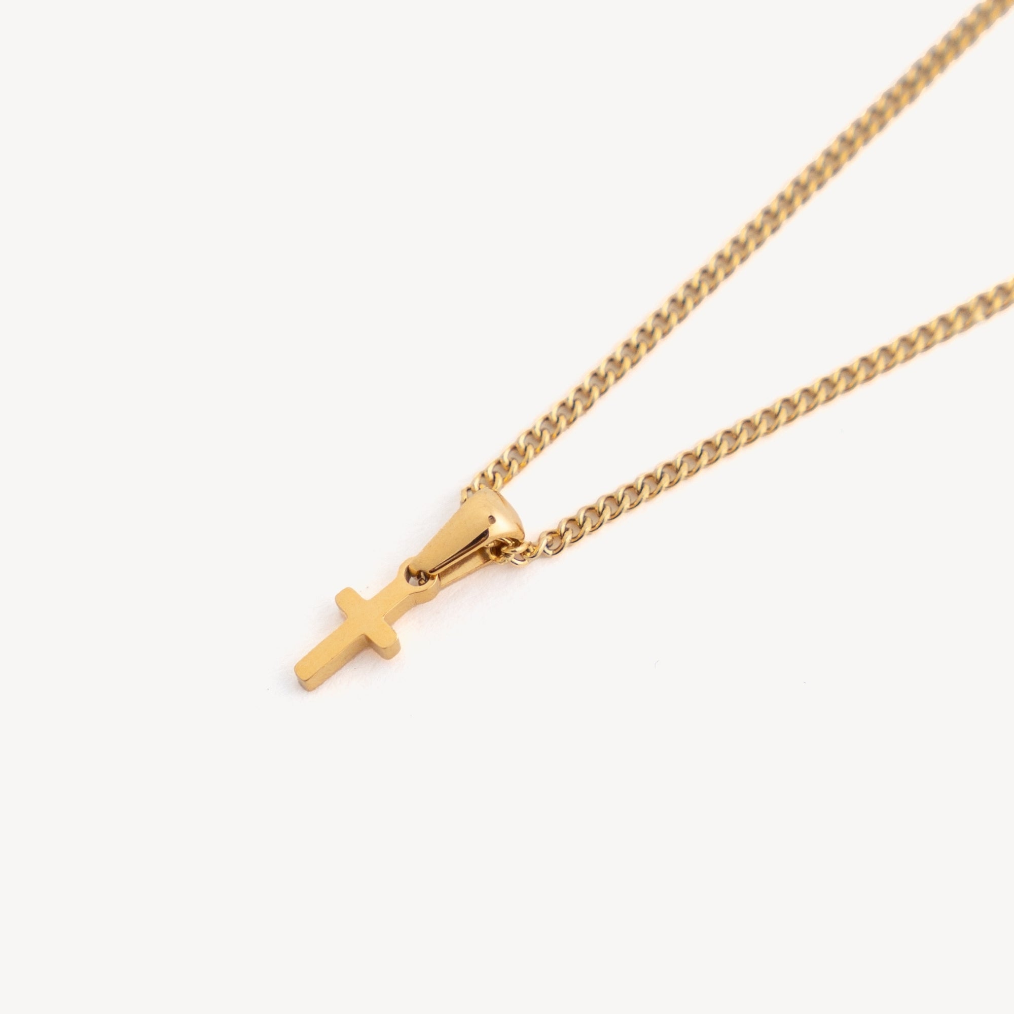 Gold necklace with a cross pendant on a white background