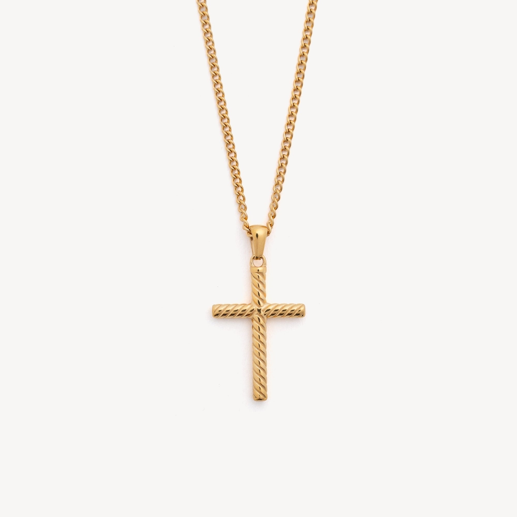 Gold cross necklace on a light gray background