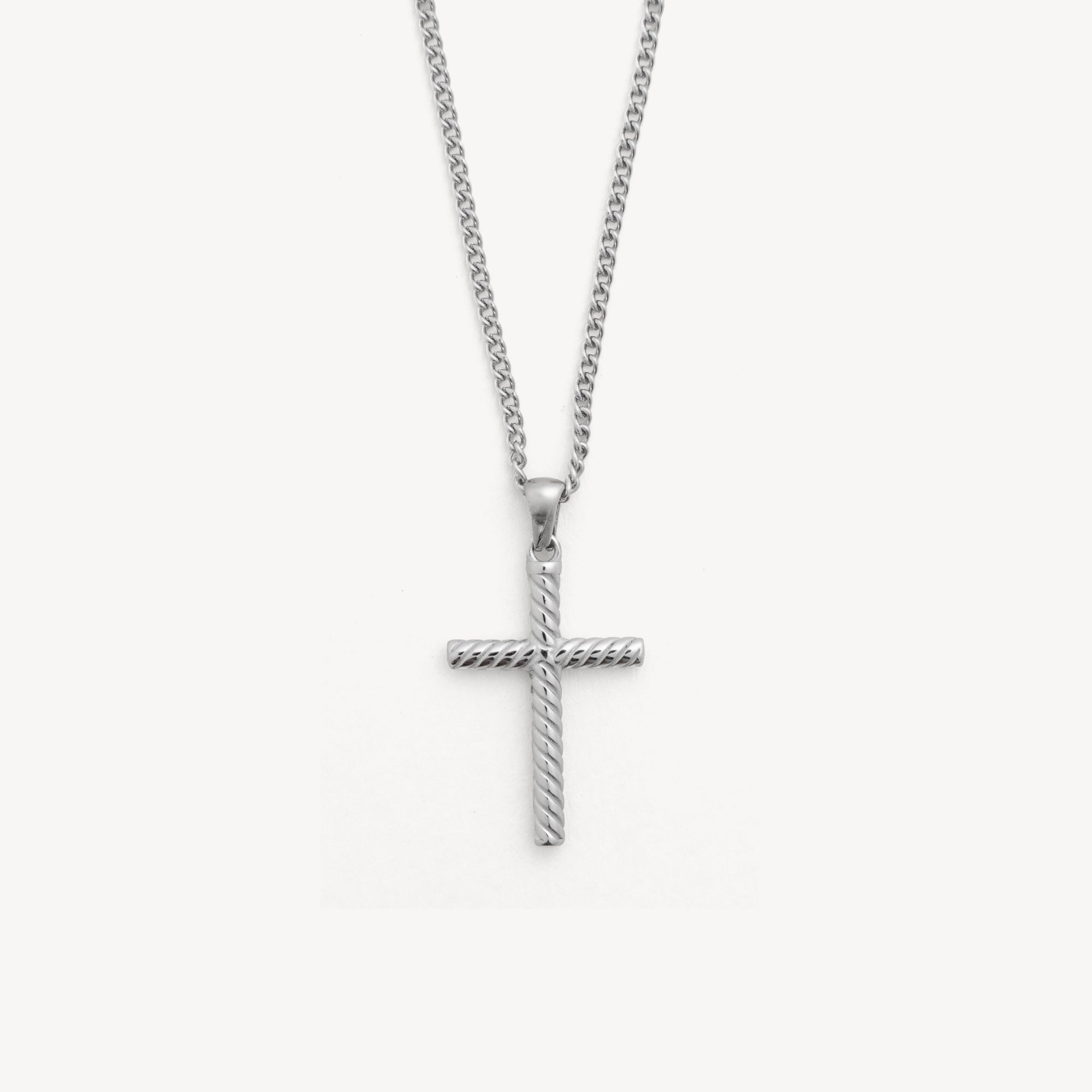 Silver cross pendant on a chain against a white background