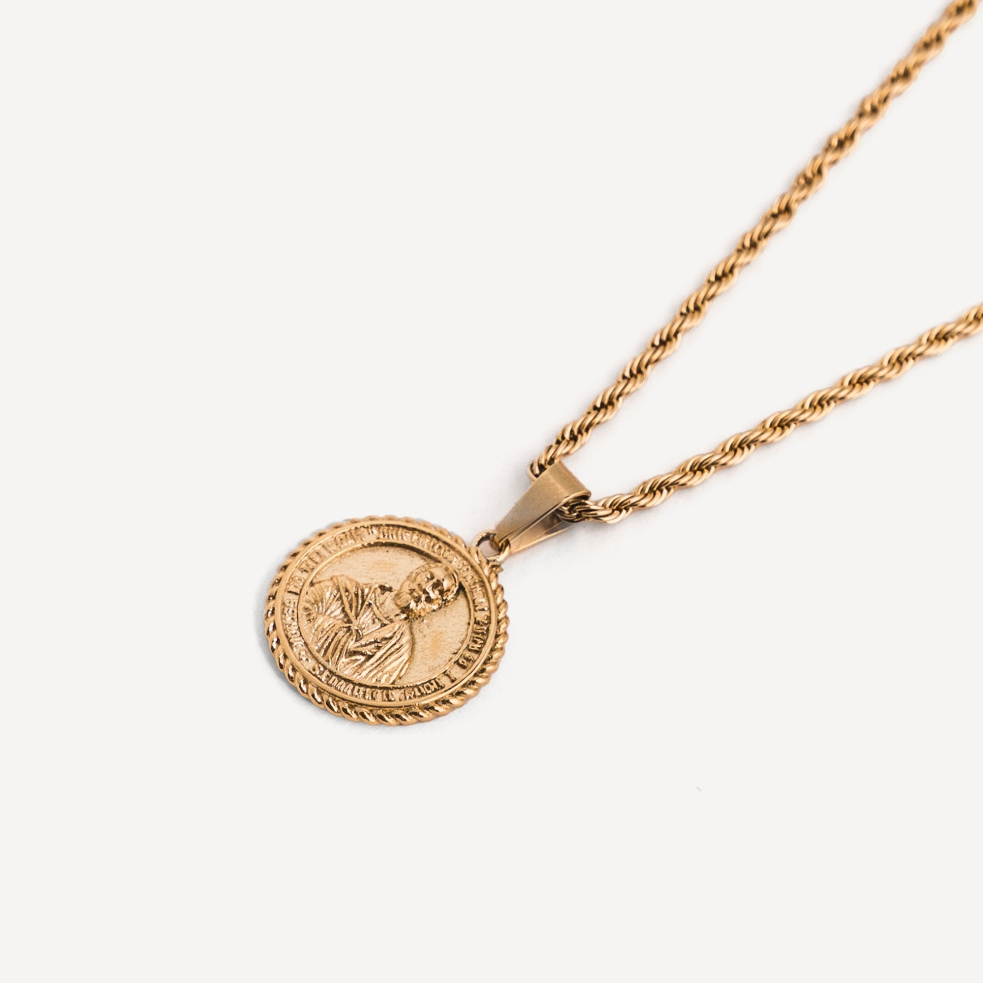 Gold necklace with a round pendant on a white background