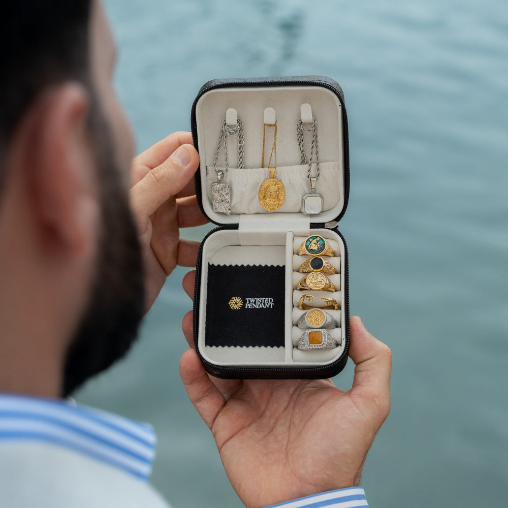Jewelry set in a Twisted Anchor box held by a person with water in the background