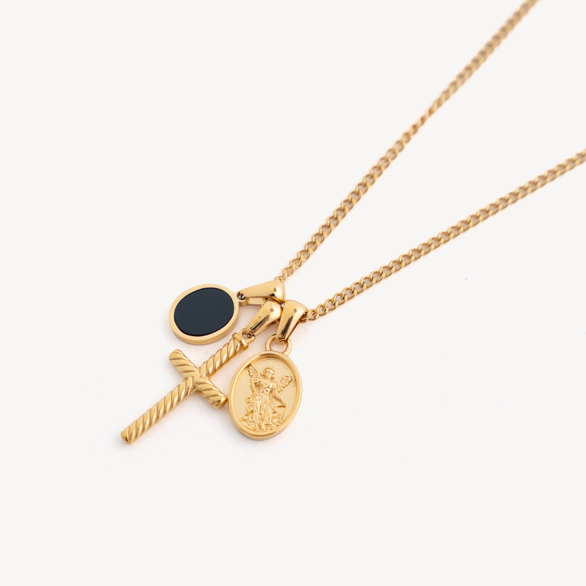 Gold necklace with two pendants on a white background