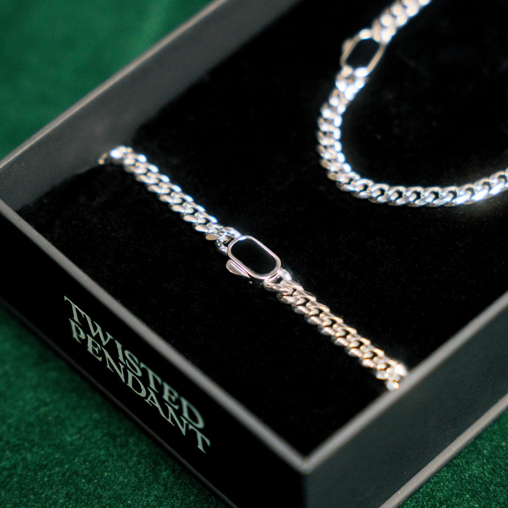 Silver twisted pendant necklace in a black box with green text