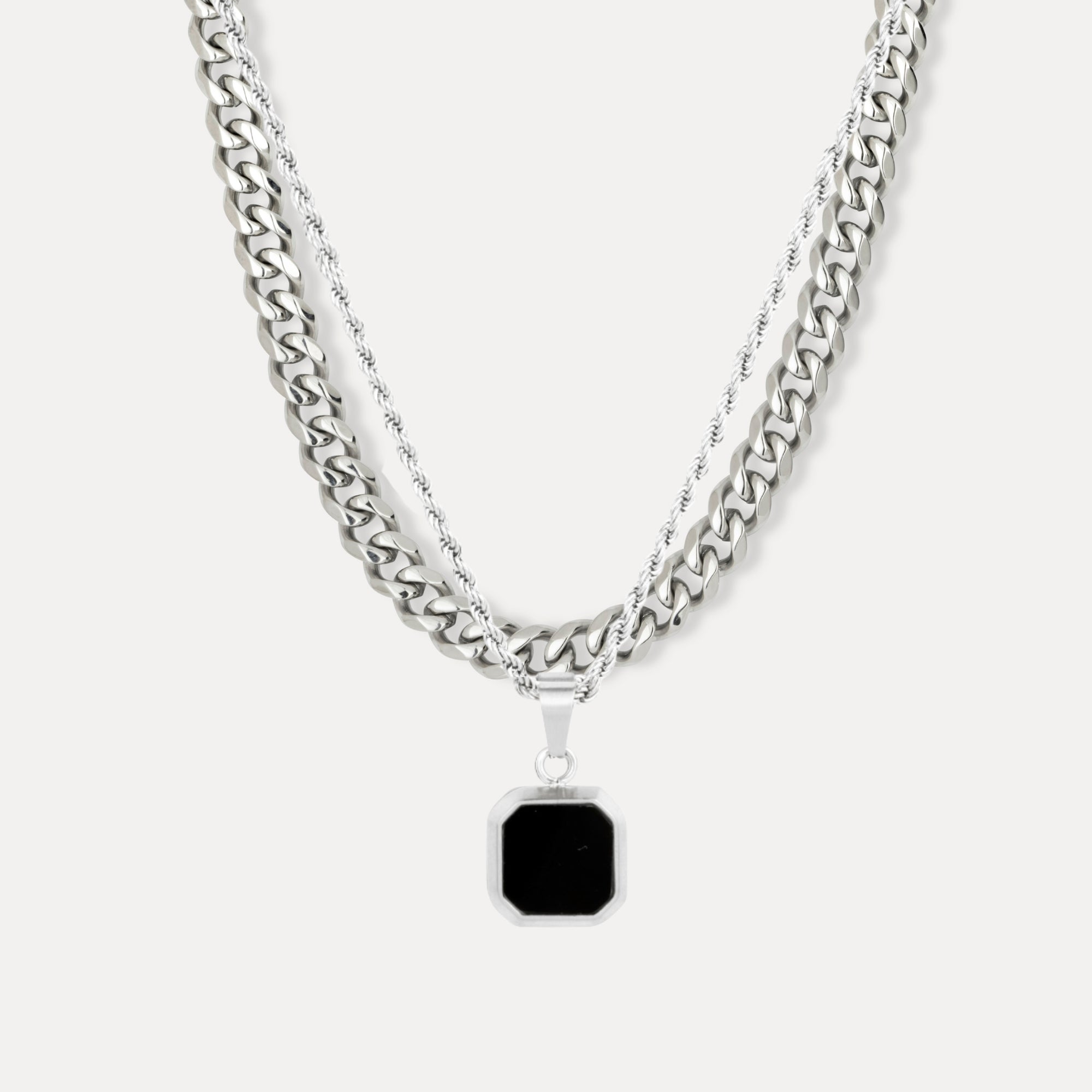 Two silver chain necklaces with a black pendant on a white background