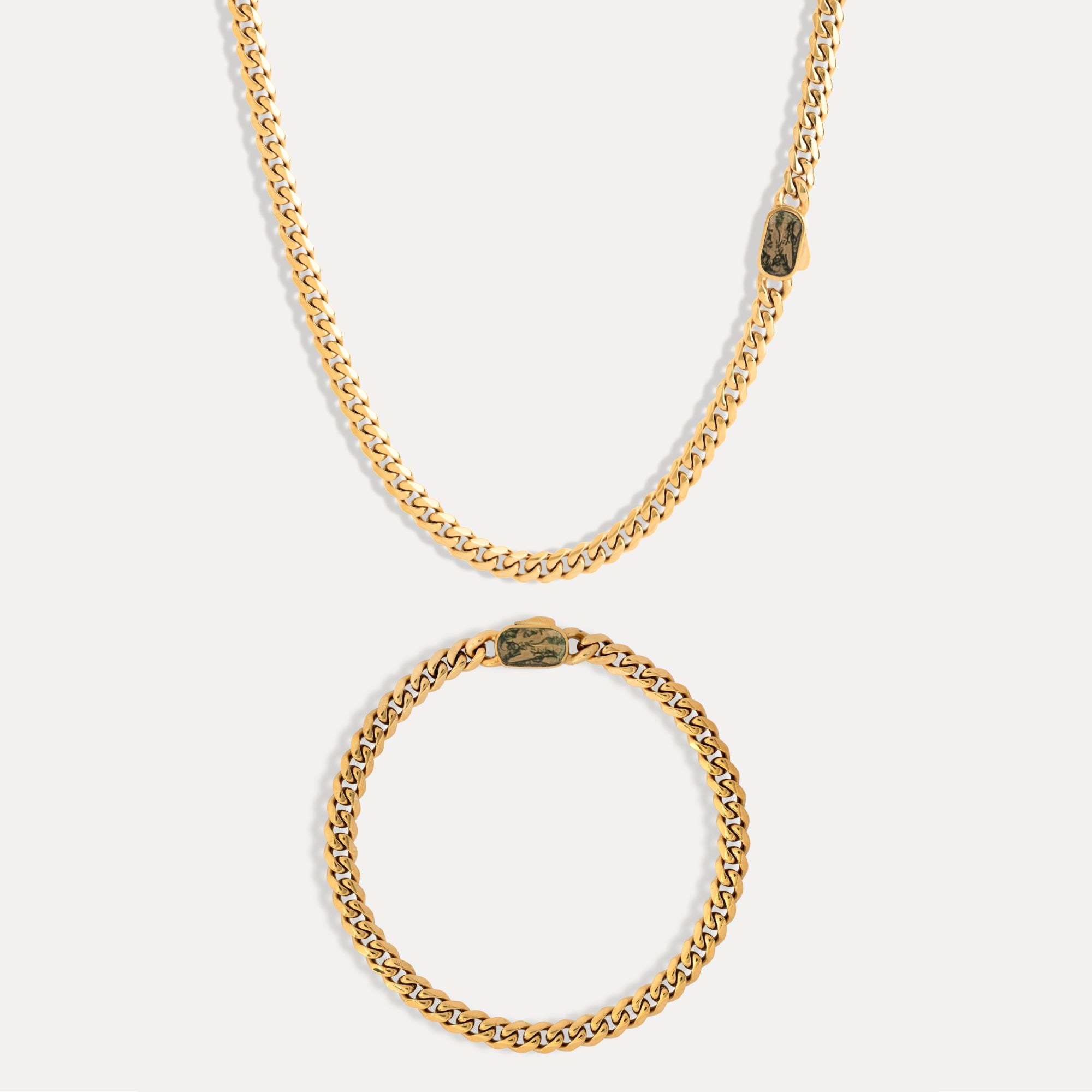 Gold chain necklace and bracelet on a white background