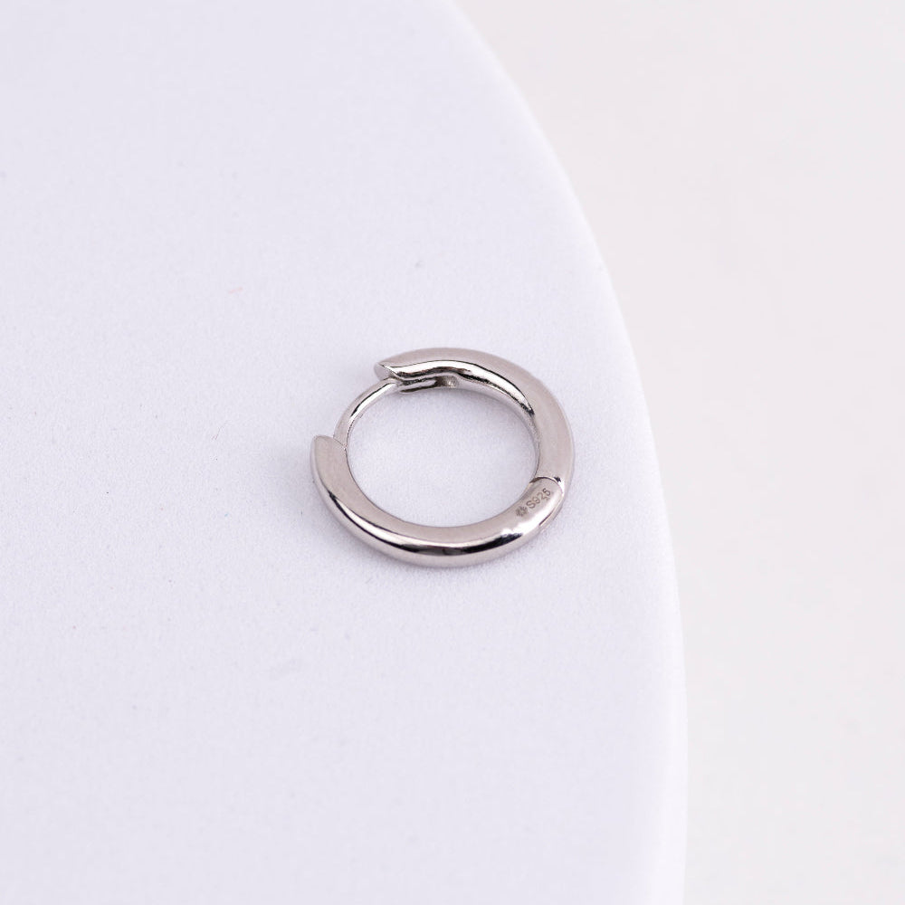 Silver hoop earring on a white background
