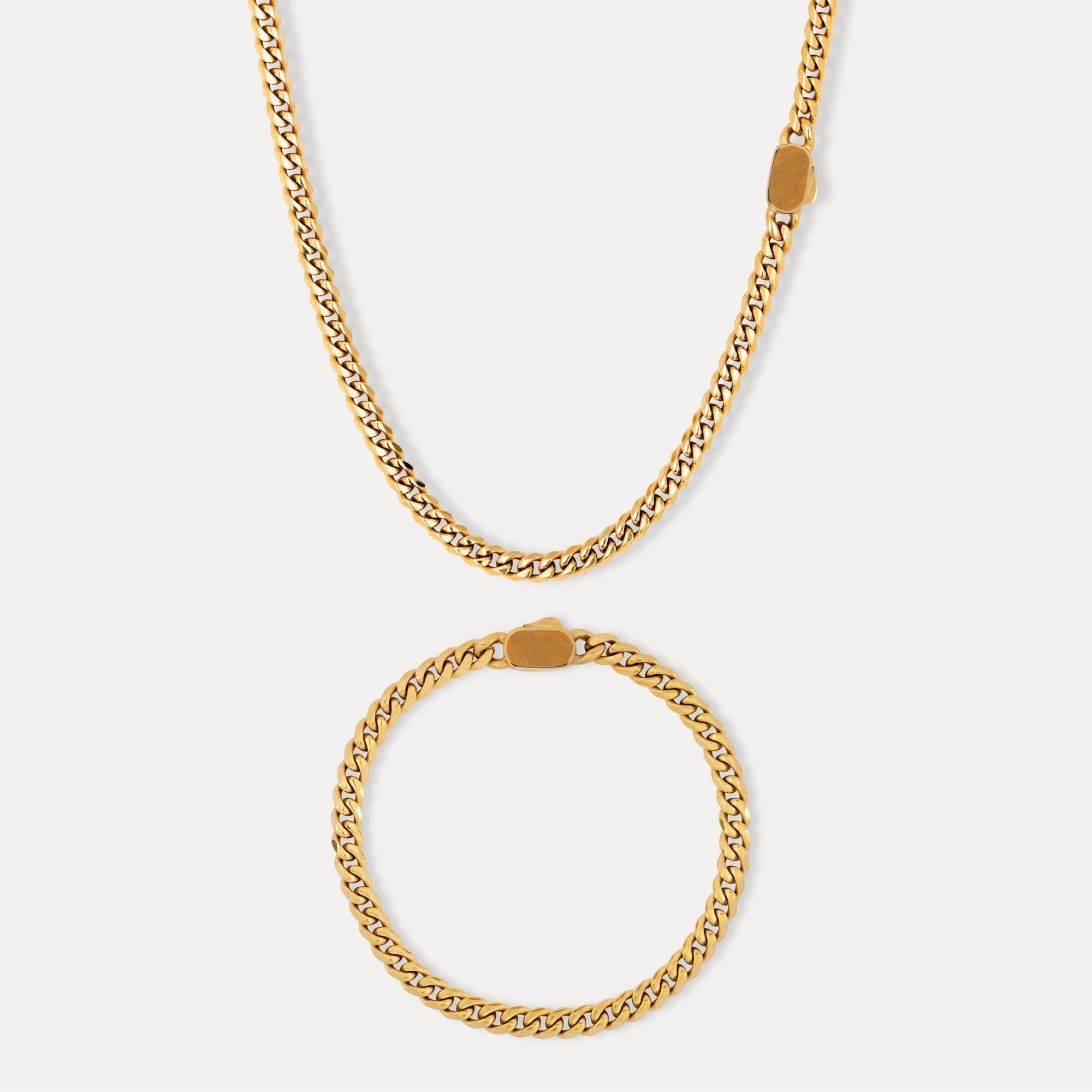 Gold chain necklace and bracelet on a white background