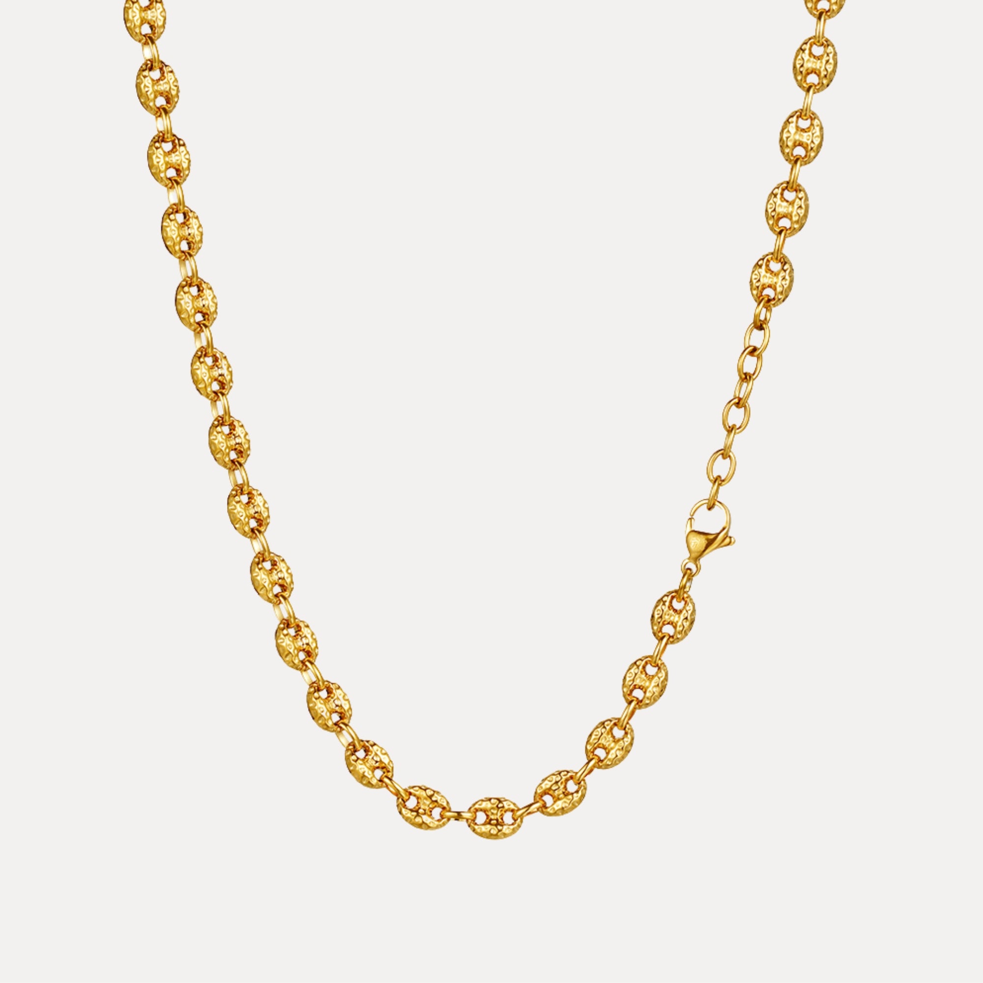 Gold chain necklace on a light gray background