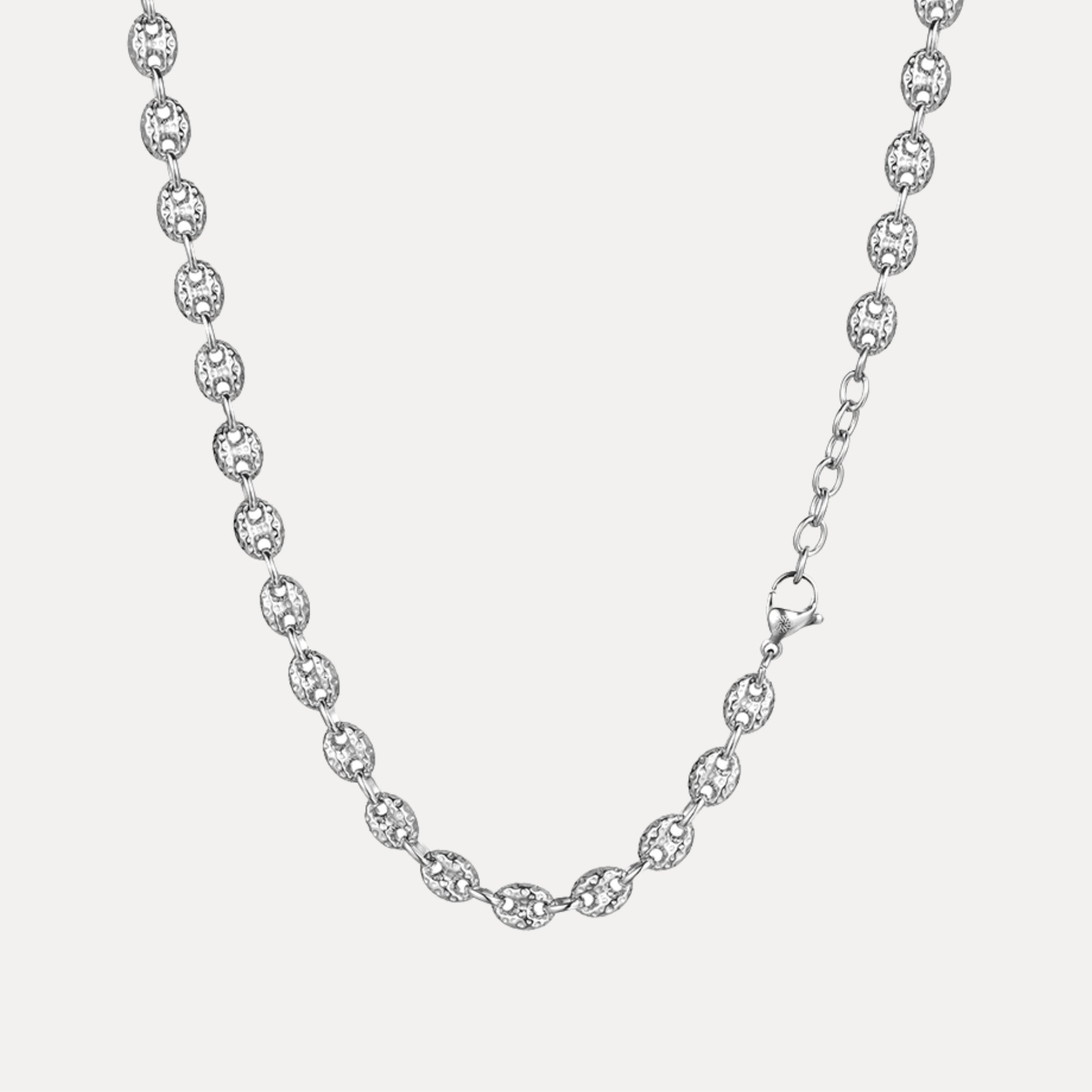 Silver chain necklace on a light gray background