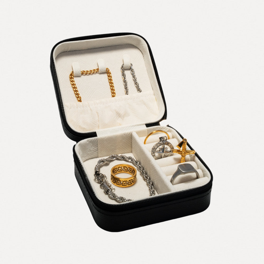 Open jewelry box with gold and silver jewelry on a white background