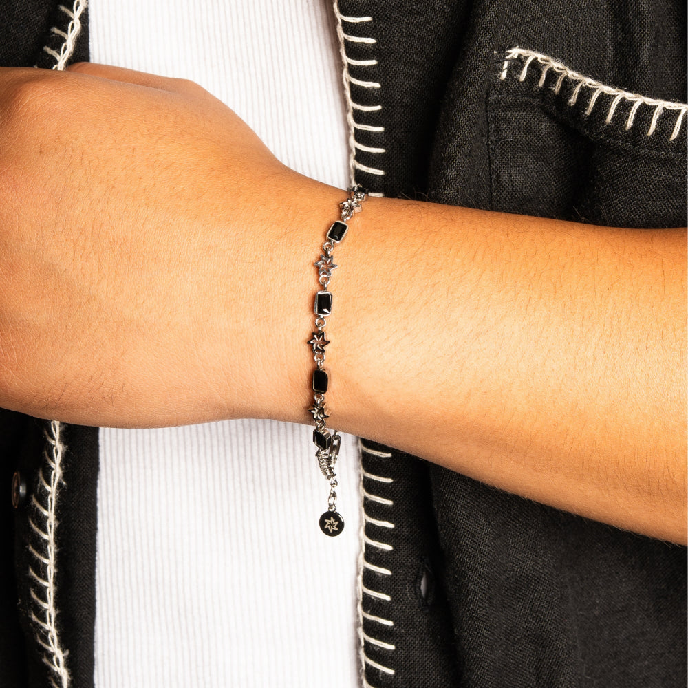 Close-up of a wrist wearing a bracelet with a black and silver design.