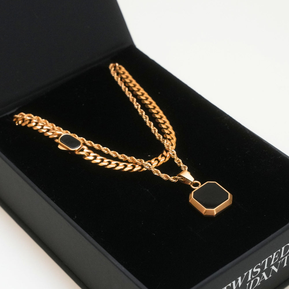 Gold chain necklace with a black pendant in a black jewelry box