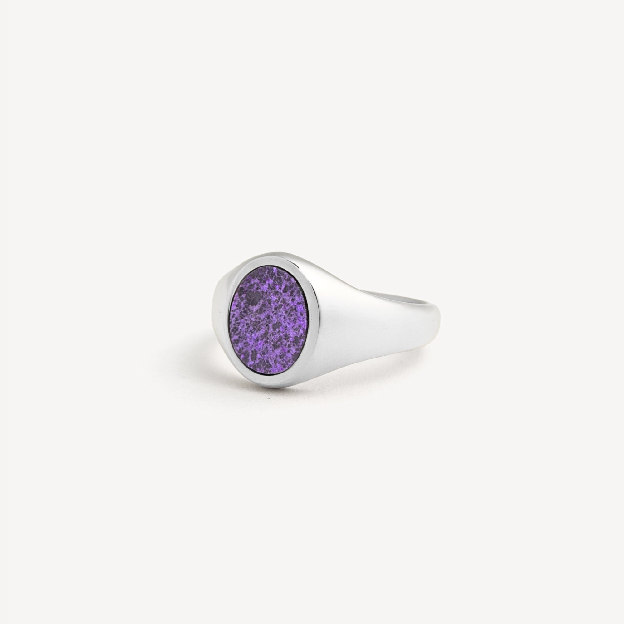 Silver ring with a purple stone on a white background
