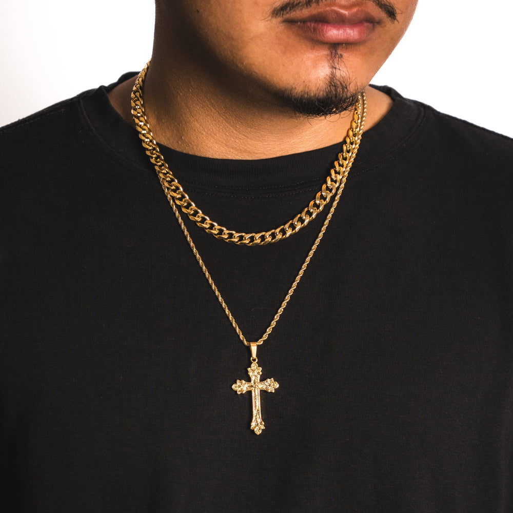 Man wearing a black shirt with a gold chain and cross pendant necklace.