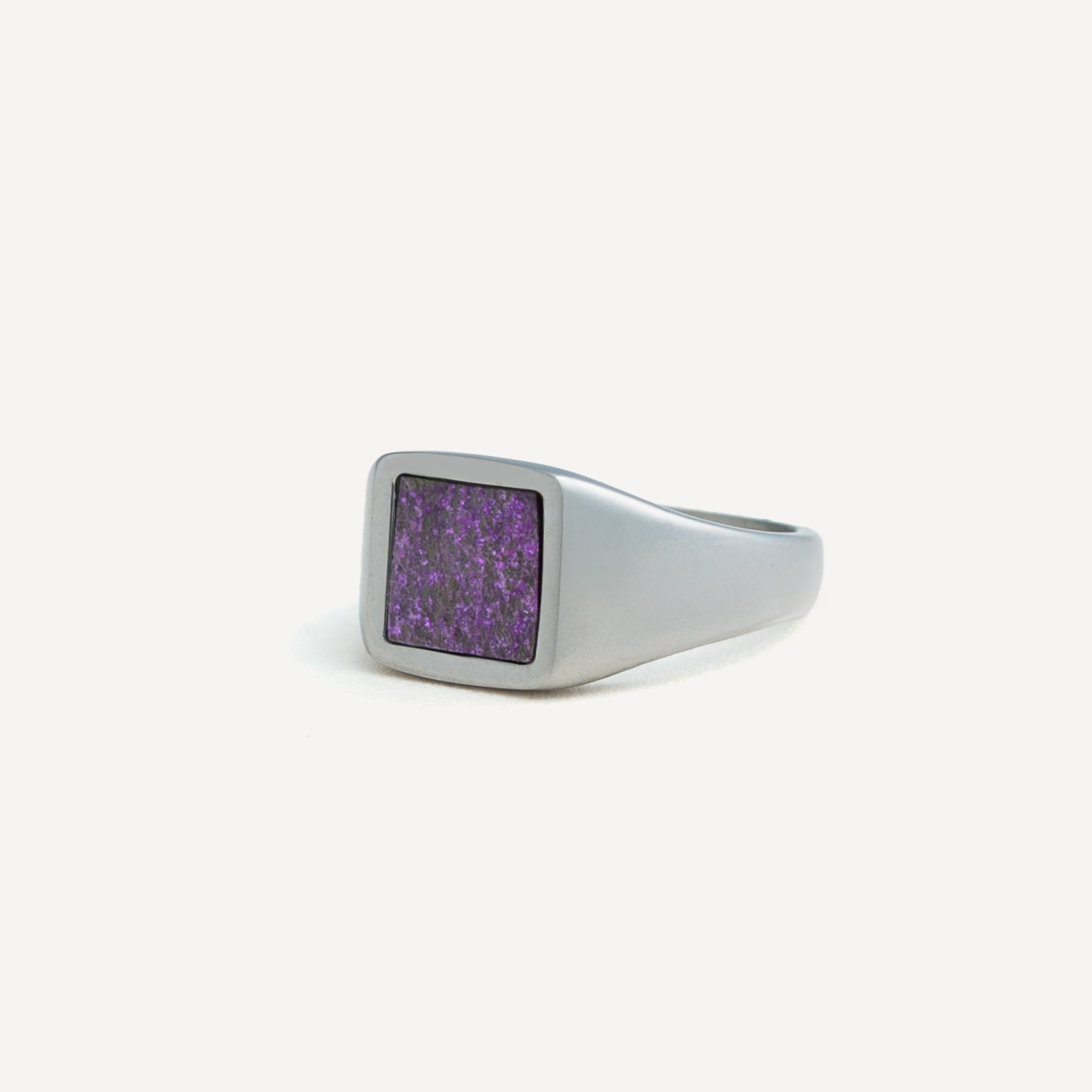 Silver ring with a purple stone on a white background