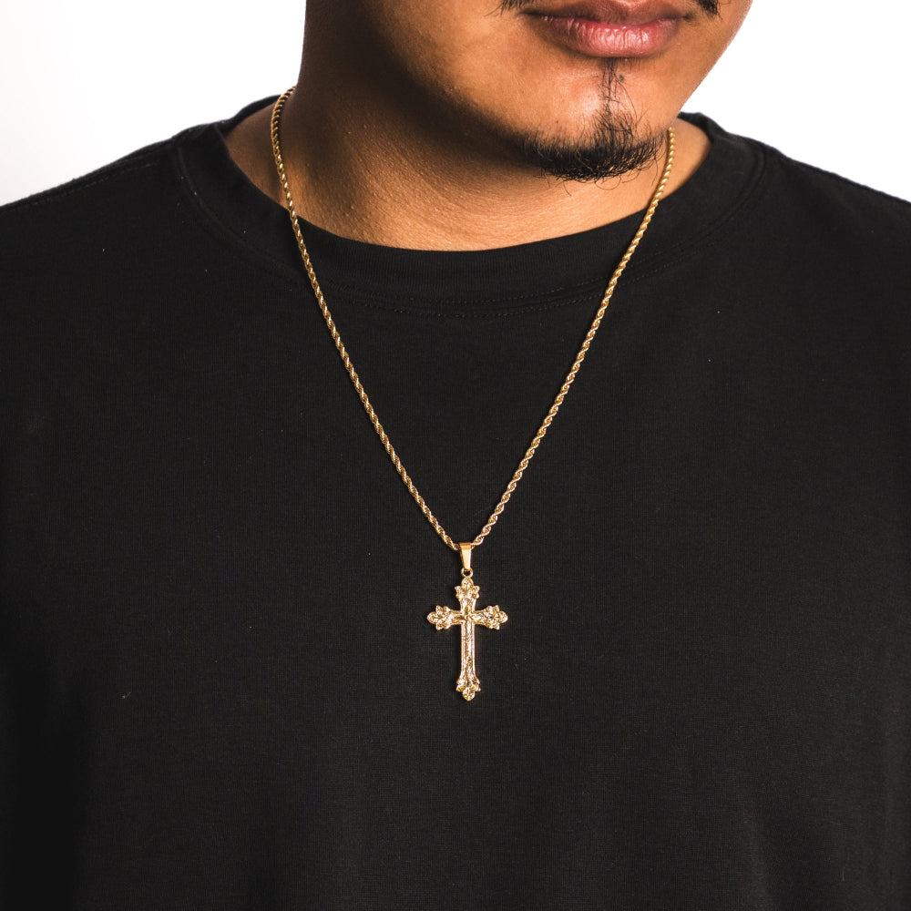 Man wearing a black shirt with a gold cross necklace on a white background