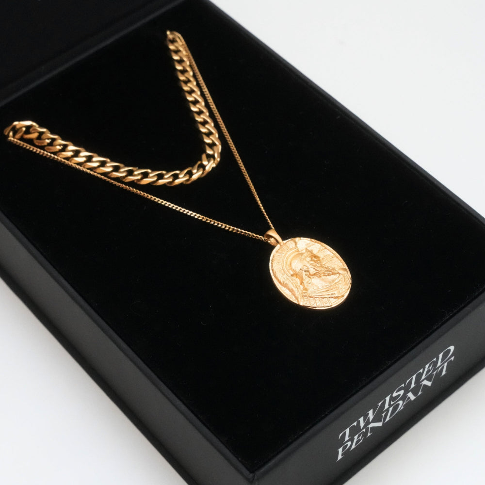 Gold chain necklace with a pendant on a black box labeled 'Twisted Pendant'.