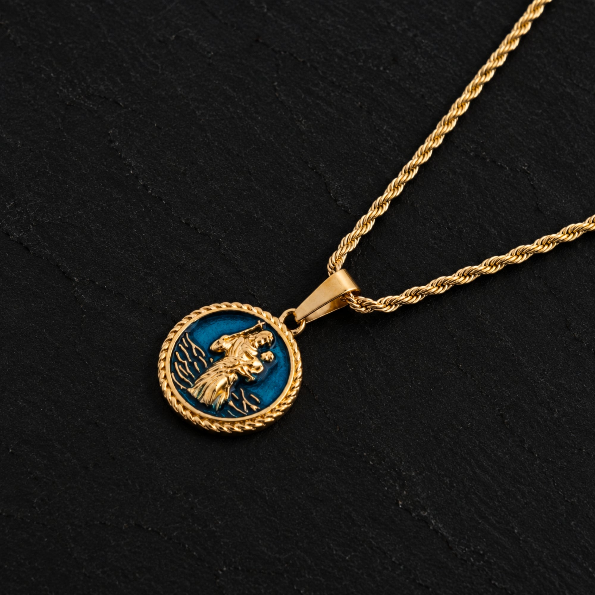 Gold necklace with a blue pendant on a black background
