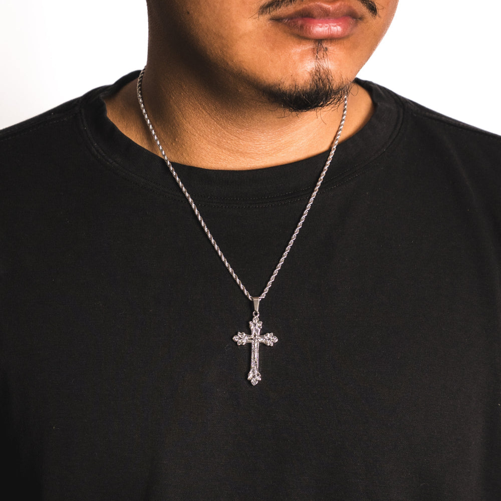 Person wearing a black shirt with a silver cross necklace