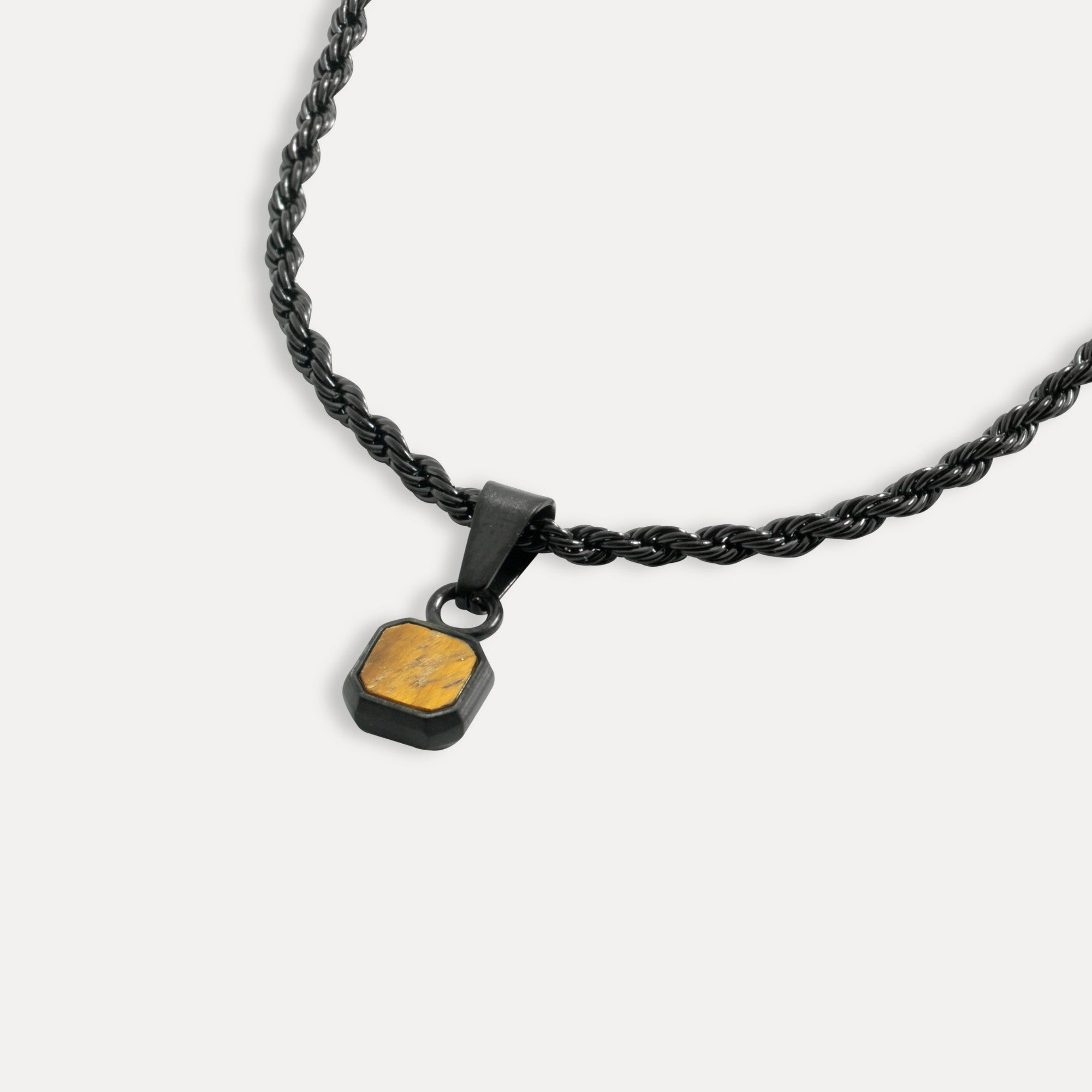 Black chain necklace with a gold pendant on a white background