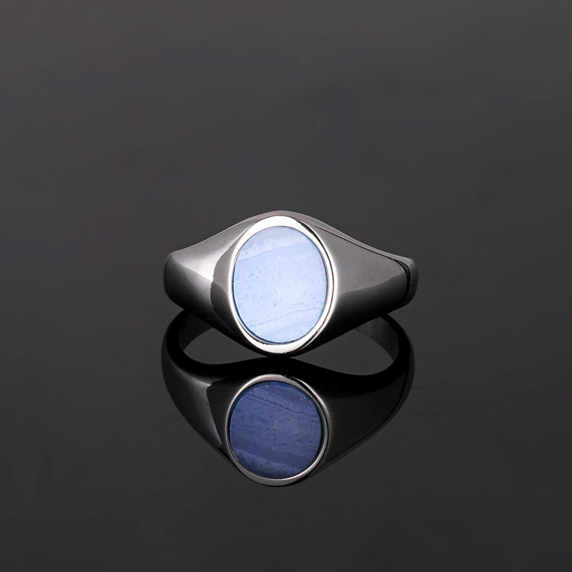 Silver ring with a blue stone on a black background