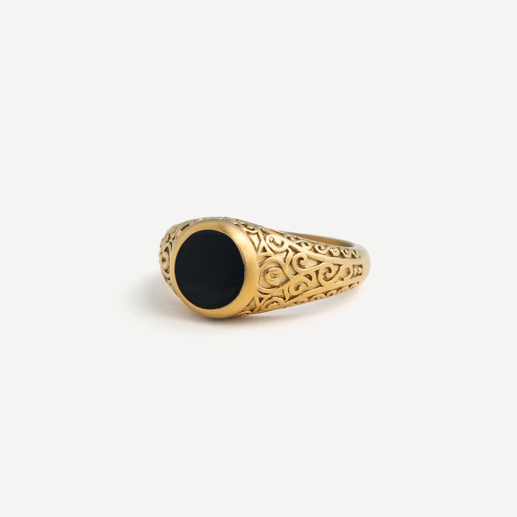 Gold ring with black stone on a white background