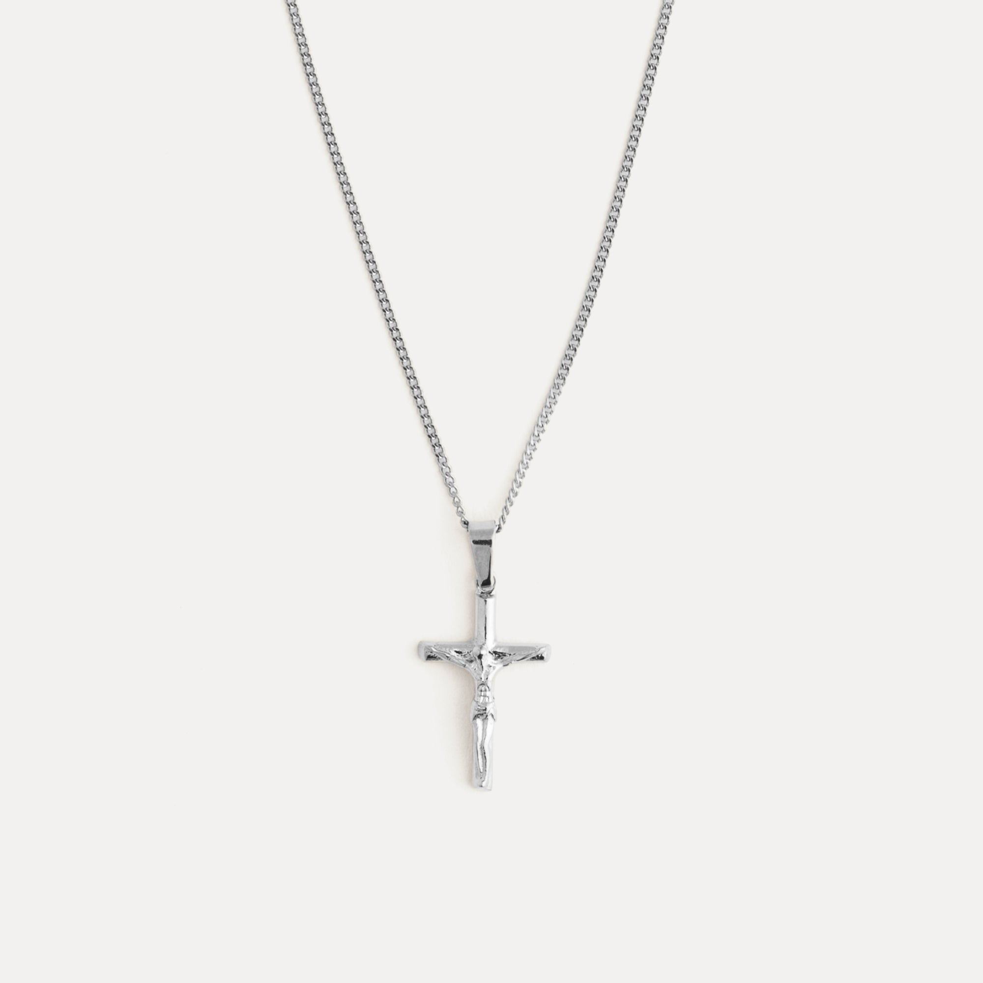 Silver cross necklace on a white background