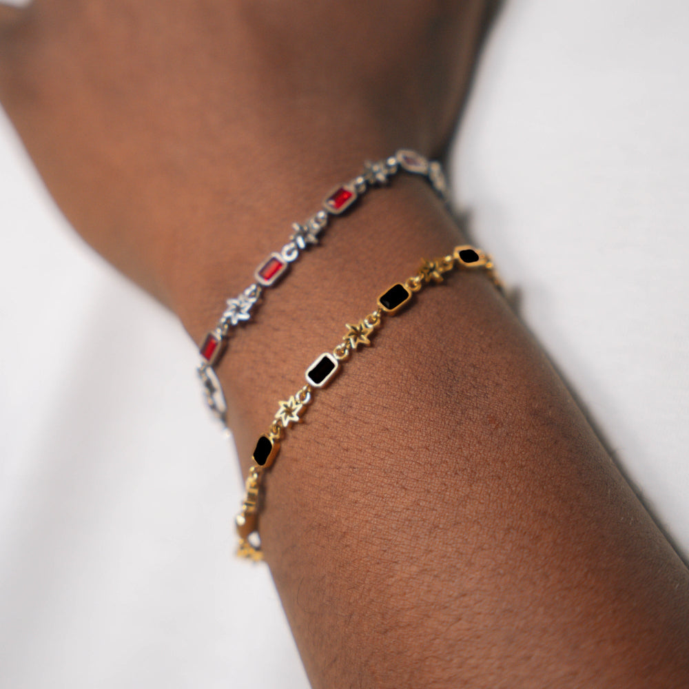 Close-up of a wrist wearing two bracelets with colored stones on a white background