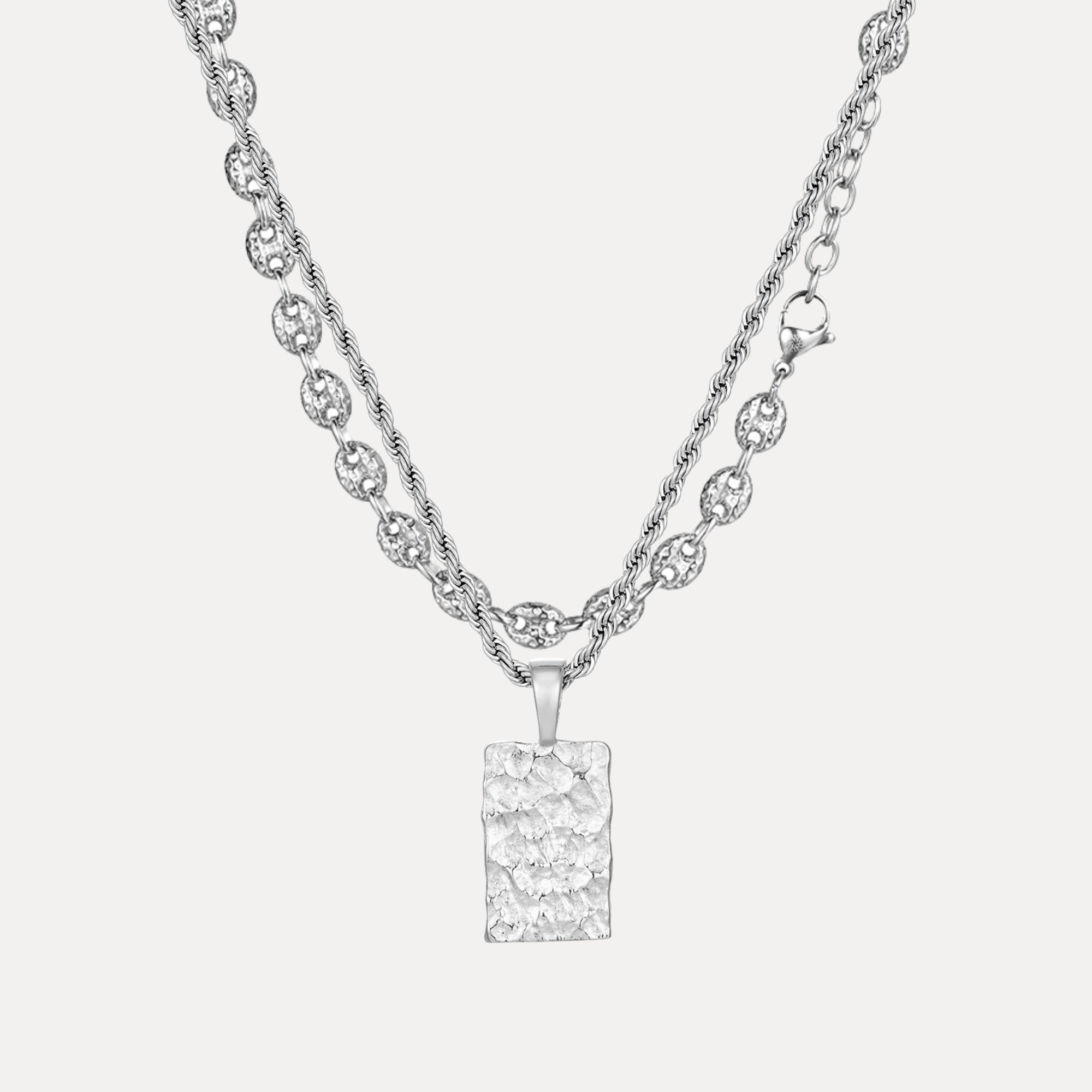 Silver necklace with a rectangular pendant on a light gray background