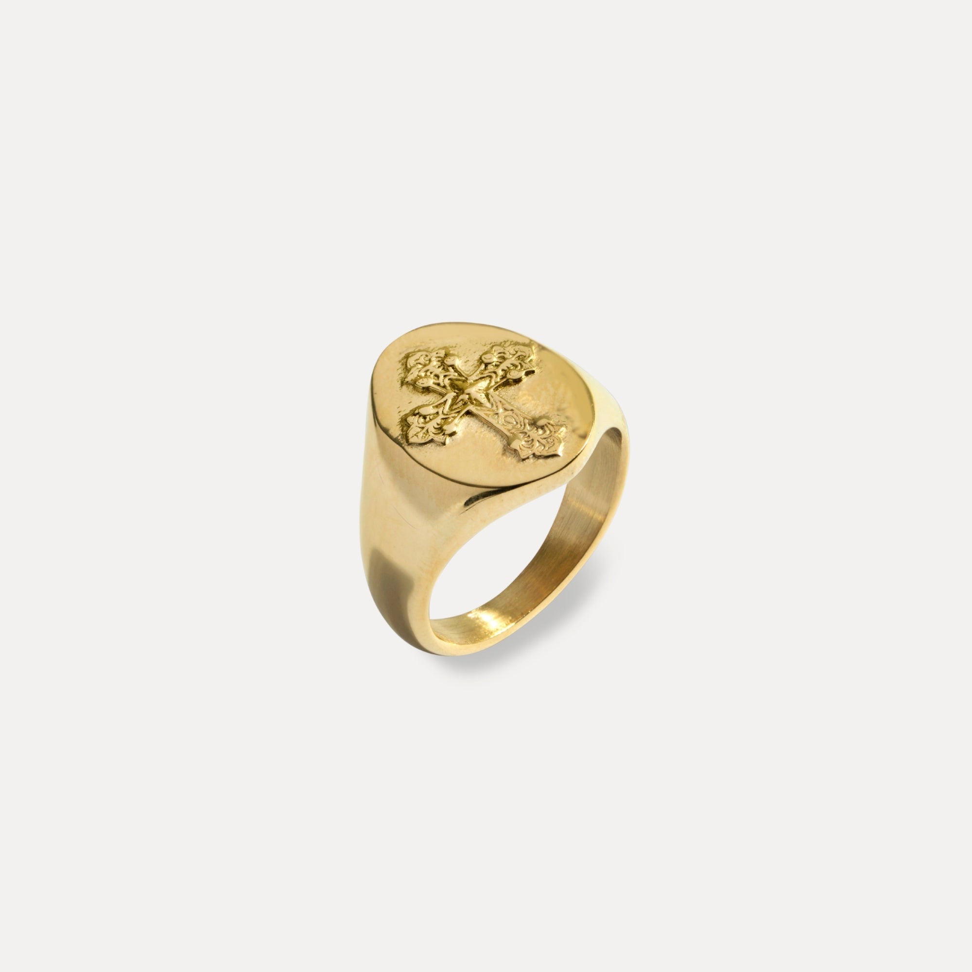 Gold ring with a cross design on a white background