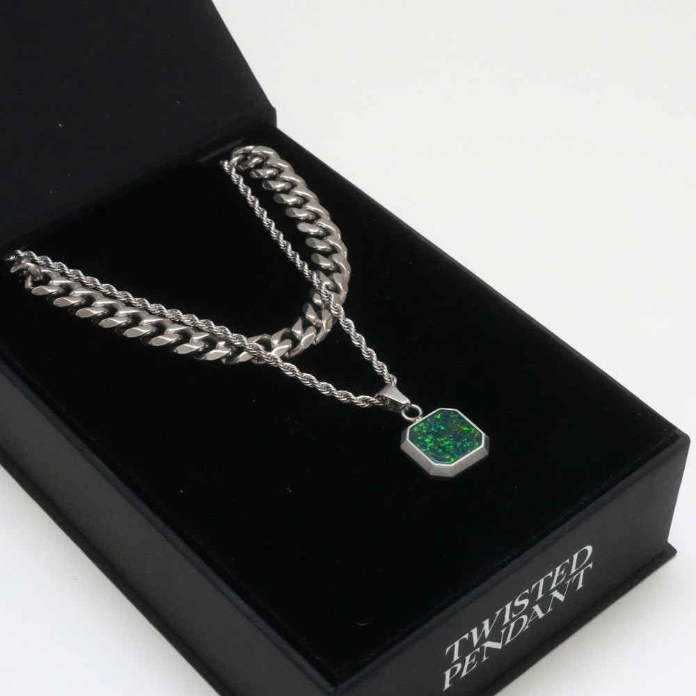 Silver chain necklace with a green pendant on a black box labeled 'Twisted Pendant'.