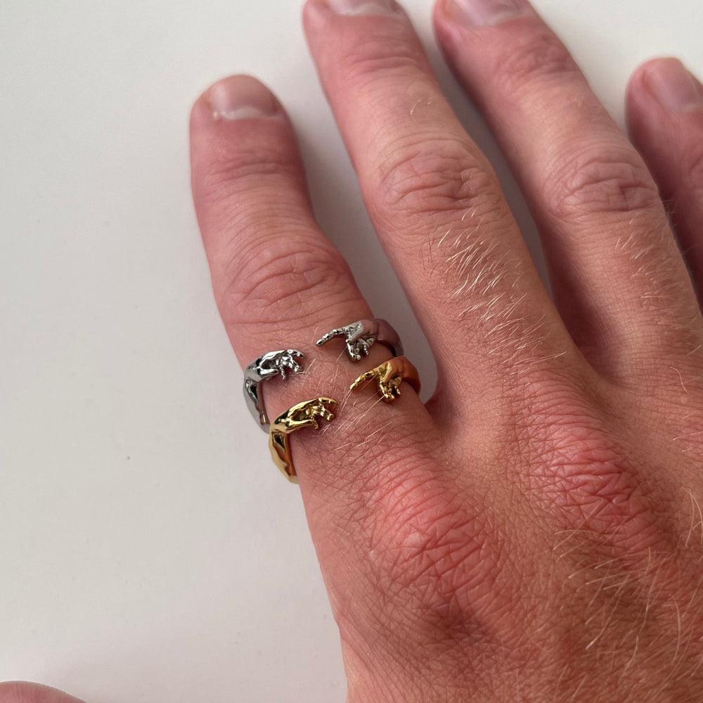 Hand wearing three gold rings on a white background