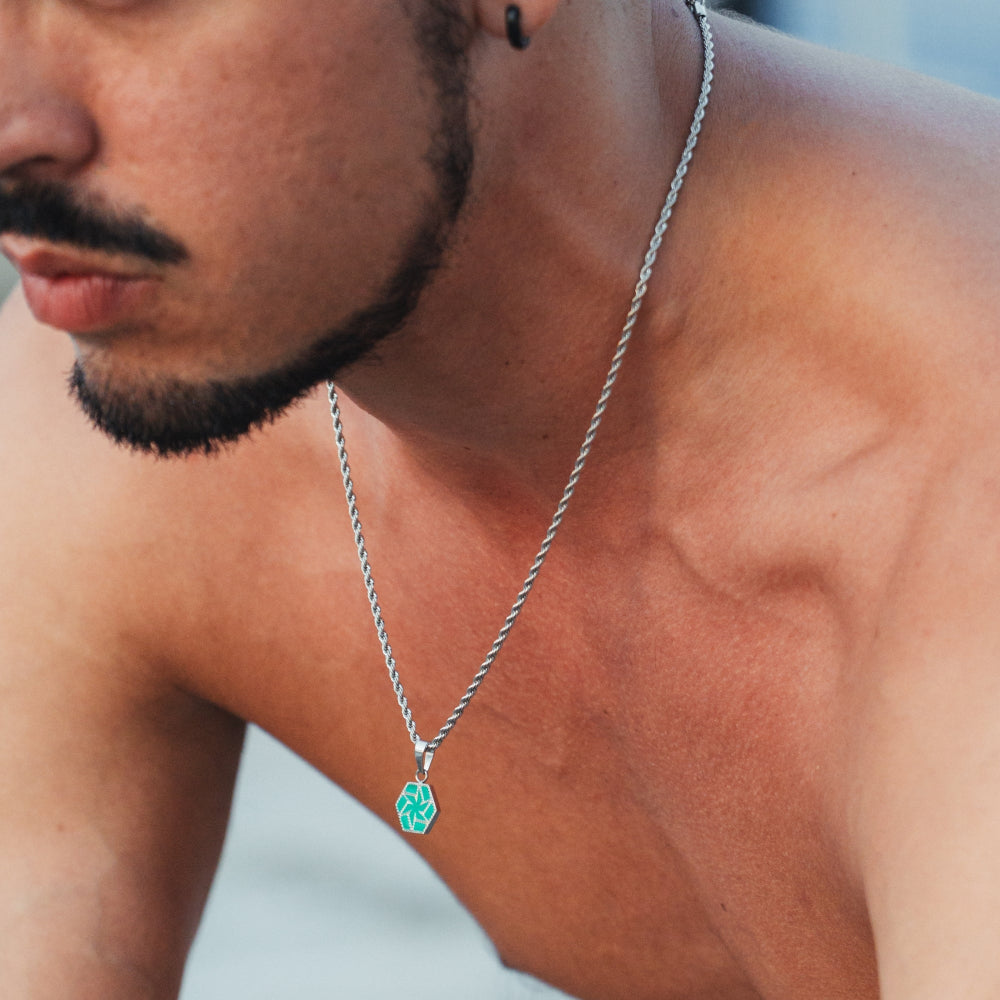 Man wearing a silver necklace with a green pendant