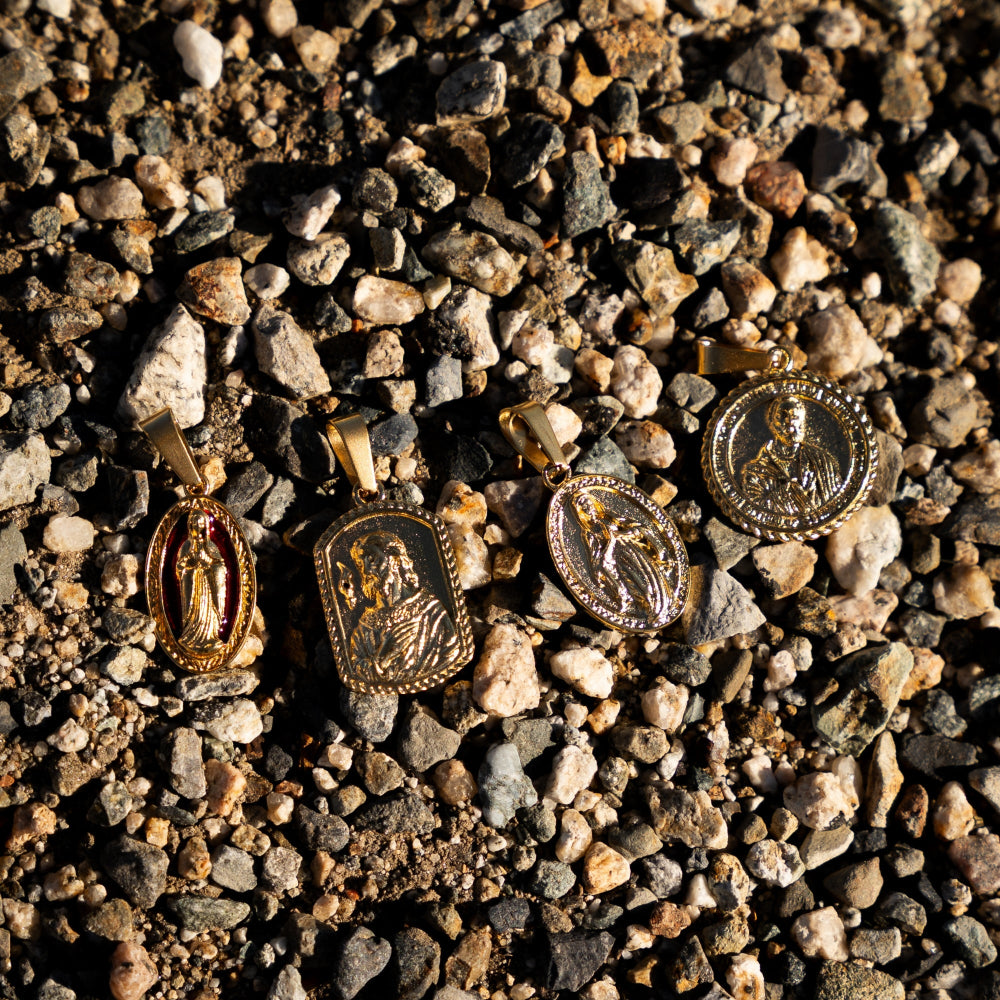 Gold religious pendants on a bed of small stones